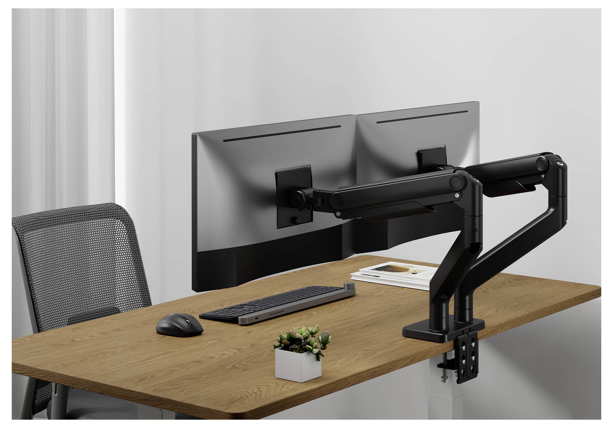 Dual-Monitor-Aufbau auf einem Holzschreibtisch mit Tastatur, Maus und kleiner Topfpflanze vor einem hellgrauem Hintergrund.