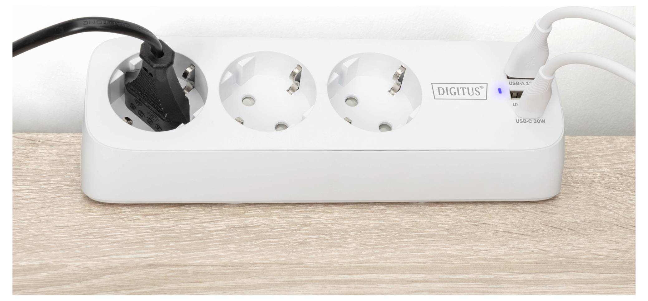 Eine weiße Steckdosenleiste mit drei europäischen Steckdosen, zwei USB-Anschlüssen und dem Markennamen „DIGITUS