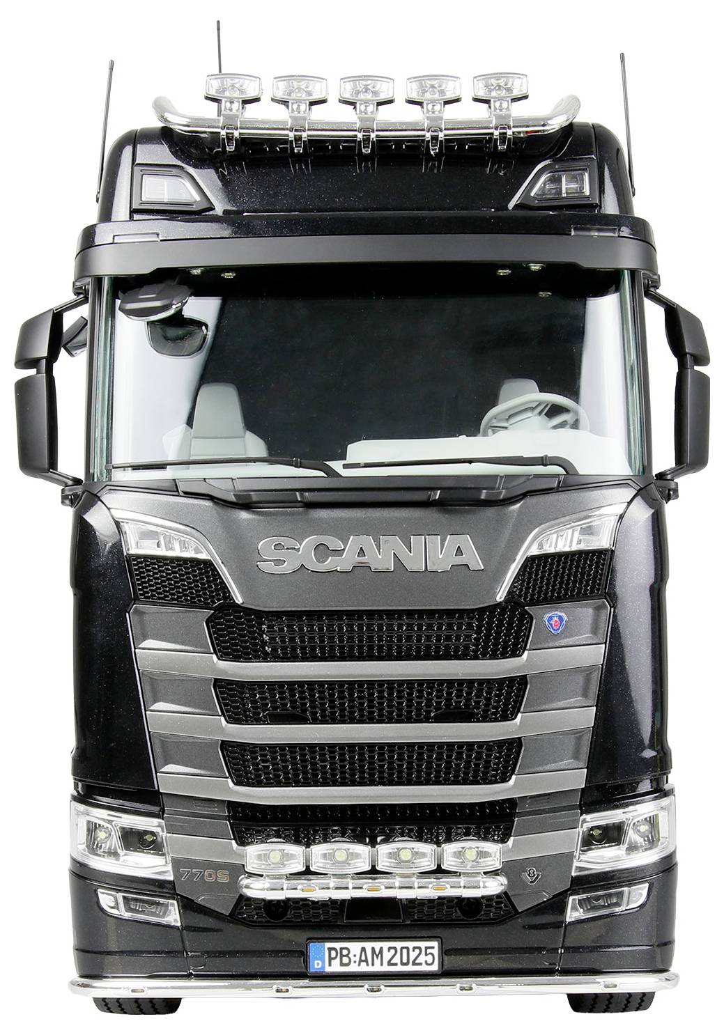 Ein schwarzer Scania-Lastwagen wird von vorne gezeigt, wobei seine Kühlergrill, Scheinwerfer und das Nummernschild mit der Aufschrift ‚PB-AM 2025' zu sehen sind.