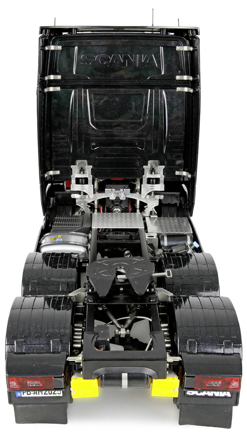 Ein Modell eines schwarzen Sattelschleppers mit nach vorne geneigter Fahrerkabine, die detaillierte Motorkomponenten und mechanische Teile darunter offenlegt.