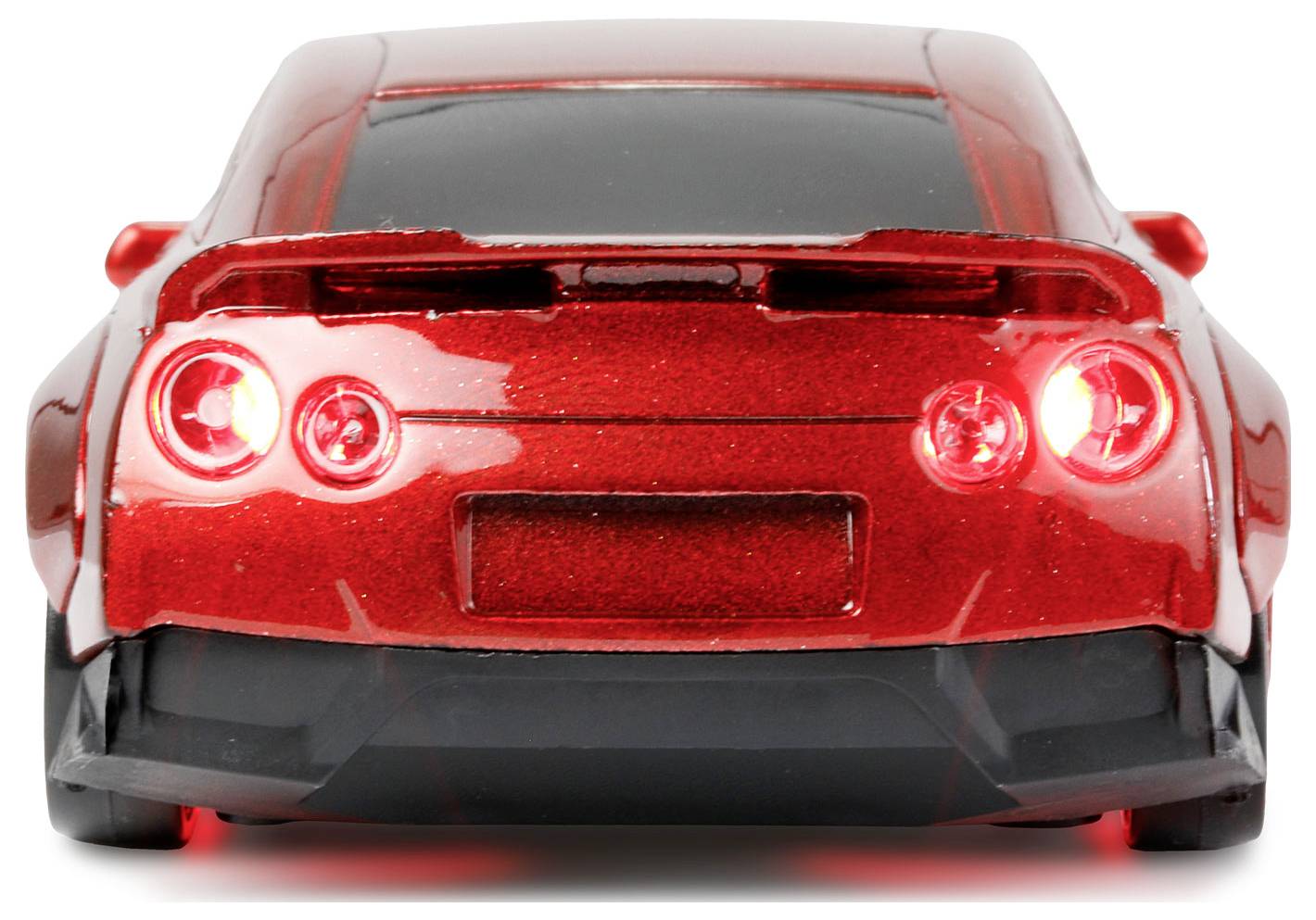 Ein roter Sportwagen von hinten, mit leuchtenden Rücklichtern.