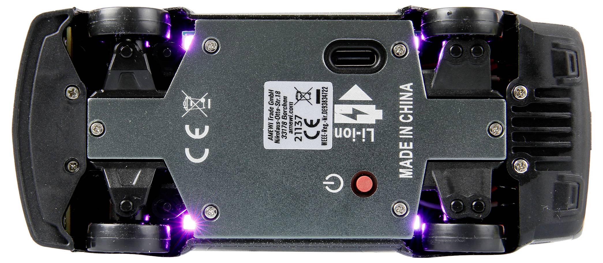 Die Unterseite eines Spielzeugautos mit sichtbaren Rädern, Schrauben, einem USB-Anschluss und einem Schalter; mit der Aufschrift 