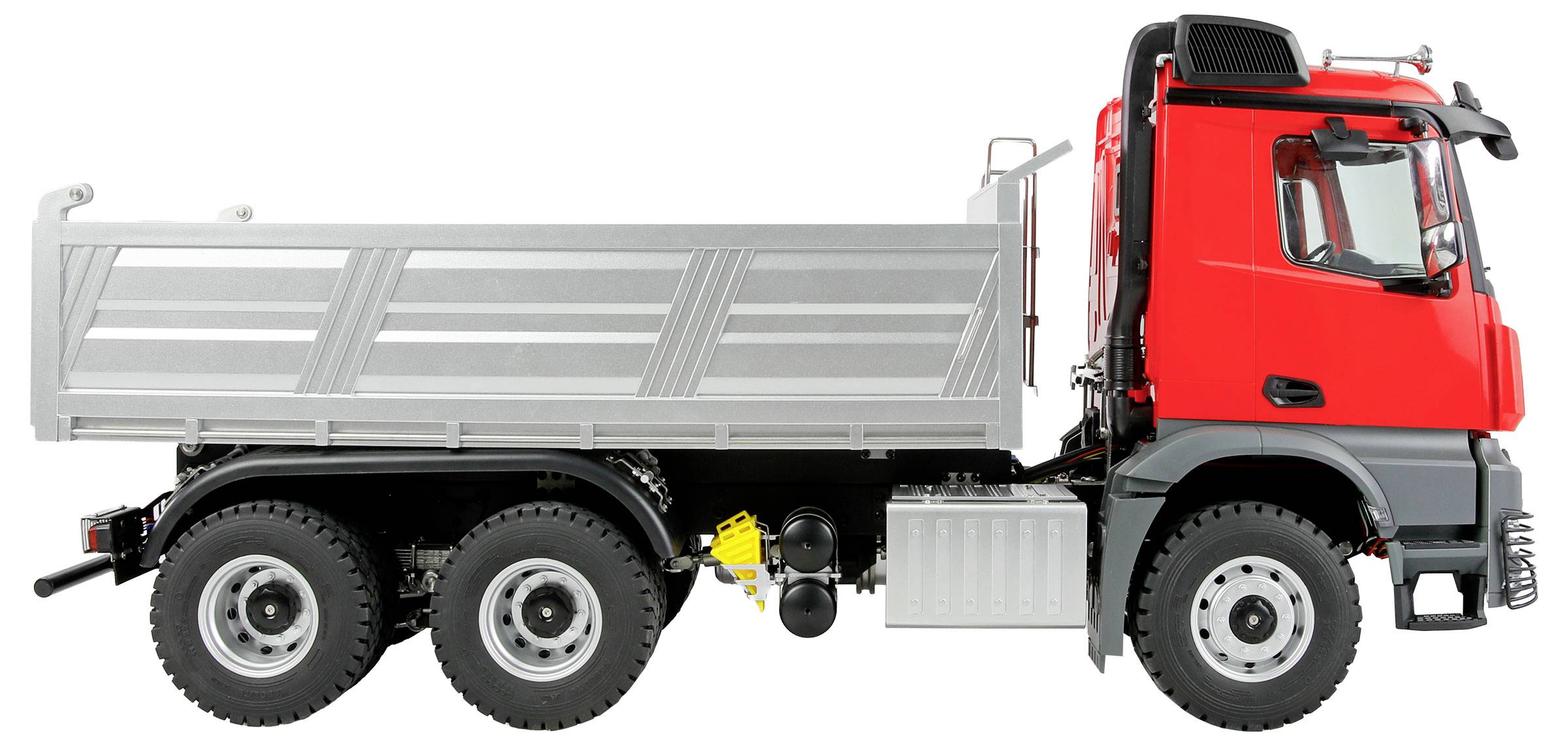 Ein roter und silberner Kipplaster mit sechs Rädern, von der Seite betrachtet, mit Fahrerhaus und großer Ladefläche.