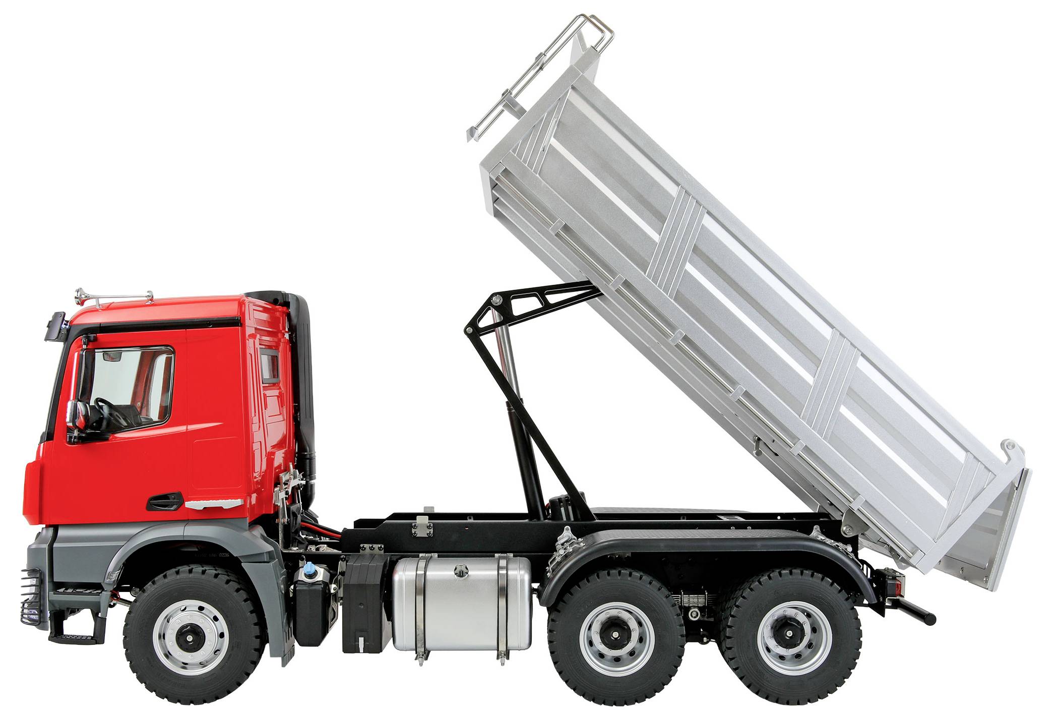 Ein roter Baustellenlastwagen mit angehobener Ladefläche zum Entladen. Der Lastwagen hat sechs Räder und wird in Seitenansicht vor einem weißen Hintergrund gezeigt.