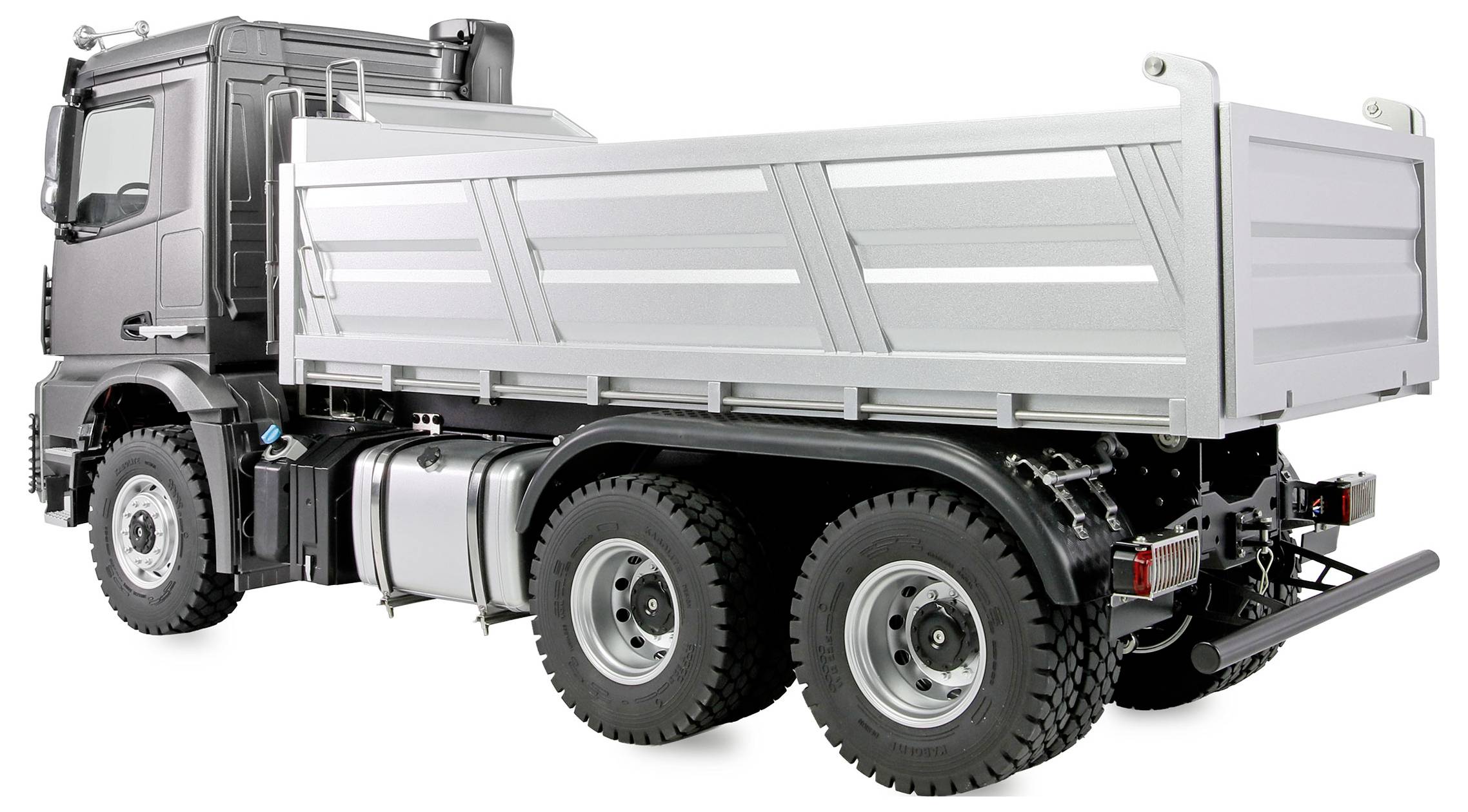 Ein großer, metallischer Lieferwagen mit sechs Rädern, von der Rückseite in einem seitlichen Winkel gesehen. Er hat eine silberne Ladefläche und eine schwarze Fahrerkabine.