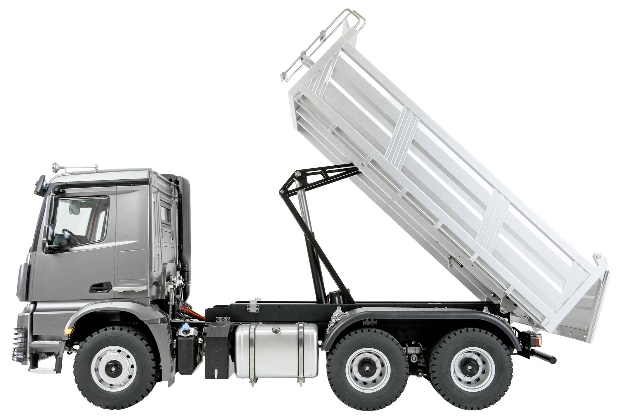 Ein großer, grauer Kipplaster mit angehobener Ladefläche, der den hydraulischen Hebevorrichtungsmechanismus sichtbar macht. Der Lastwagen wird von der Seite vor einem weißen Hintergrund gezeigt.