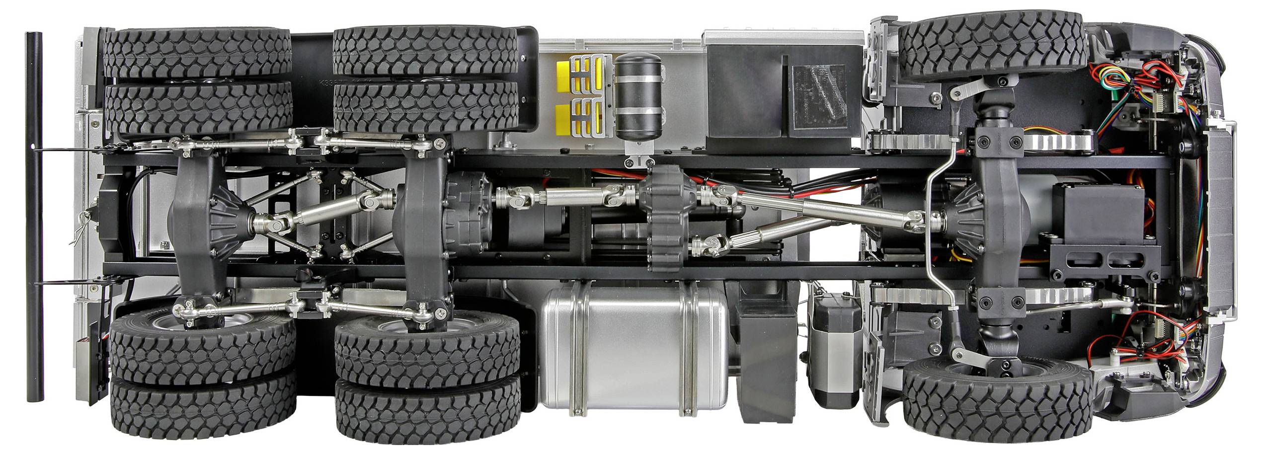 Das Bild zeigt die Unterseite eines Truck-Modells und präsentiert acht große Reifen, Federsysteme und mechanische Komponenten im Detail.