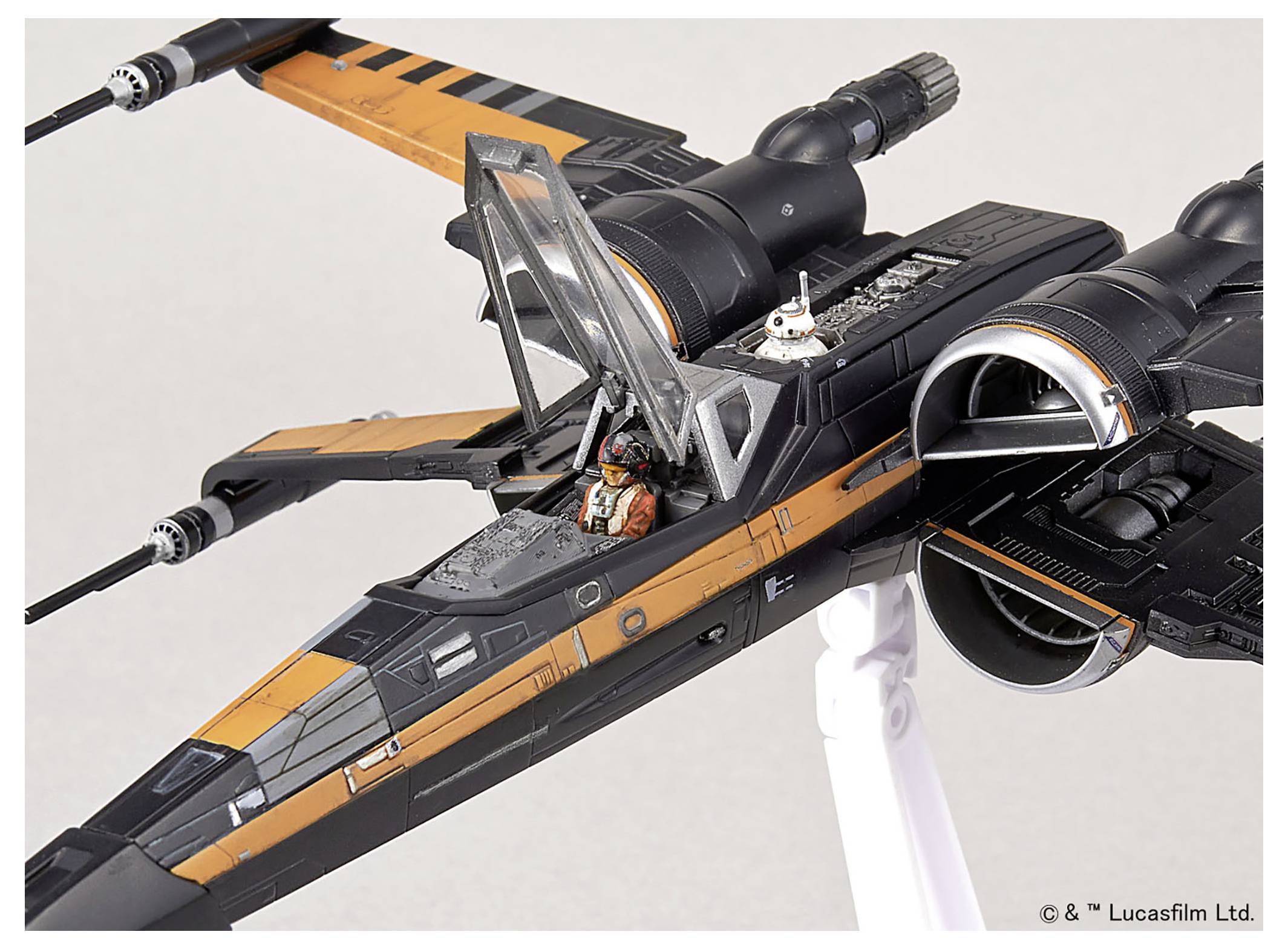 Ein Modell eines X-Wing-Sternenjägers mit offenem Cockpit, in dem eine Pilotenfigur sitzt und hinter dem Cockpit ein Astromechdroide zu sehen ist.