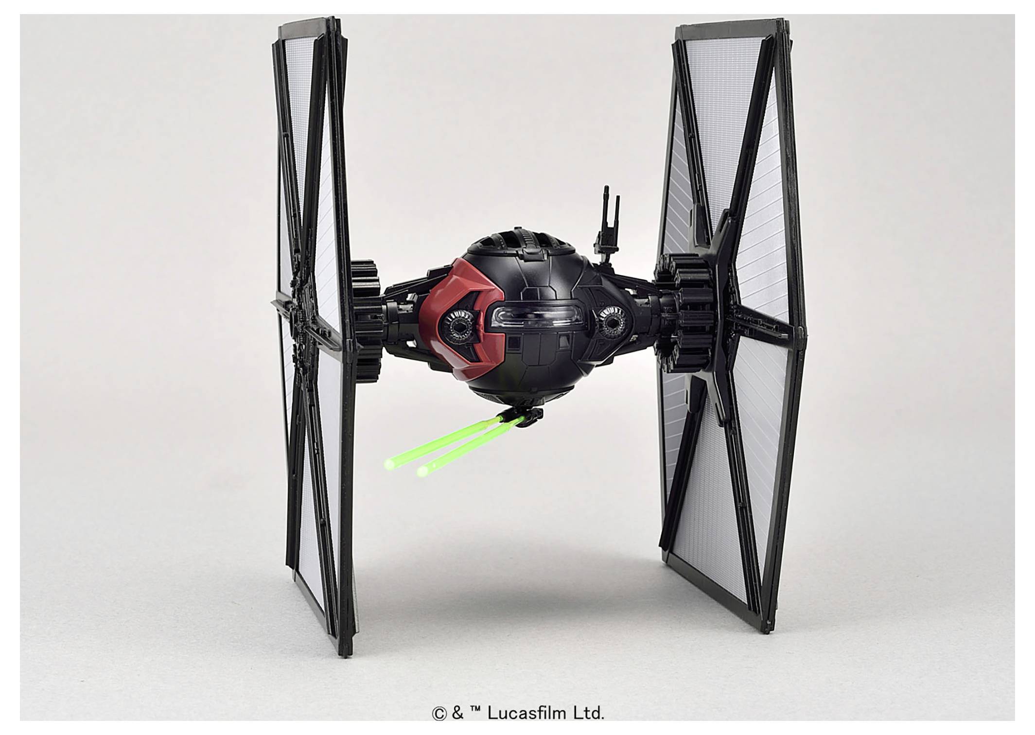 Ein schwarzes und rotes TIE-Jäger-Spielzeugmodell mit grünen Laserstrahl-Elementen. Es verfügt über eine sphärische Cockpitzelle und große Solarflügel.