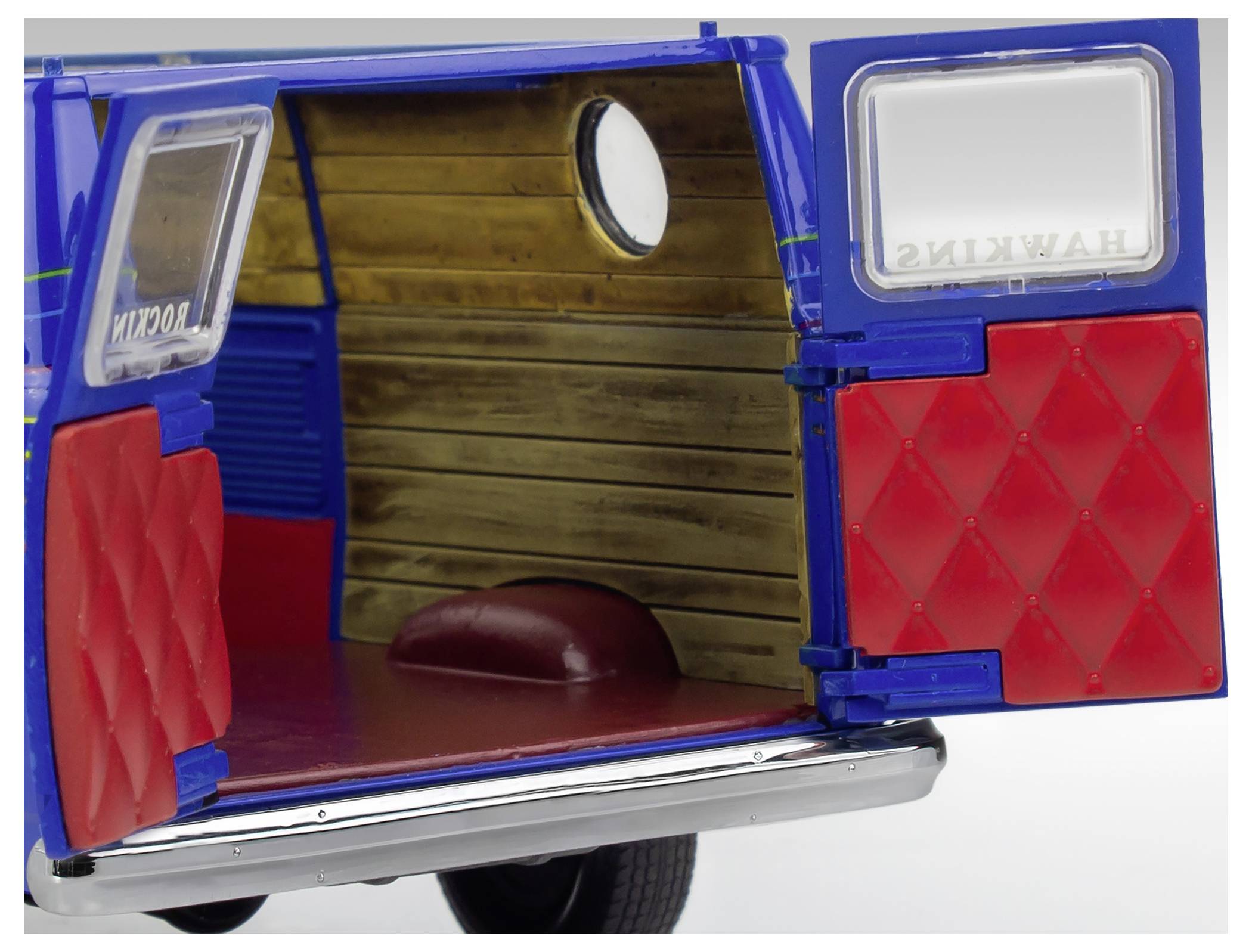 Öffnen Sie die hinteren Türen eines blauen Oldtimer-Vans mit rotem Innenraum und Holzvertäfelung an den Wänden.