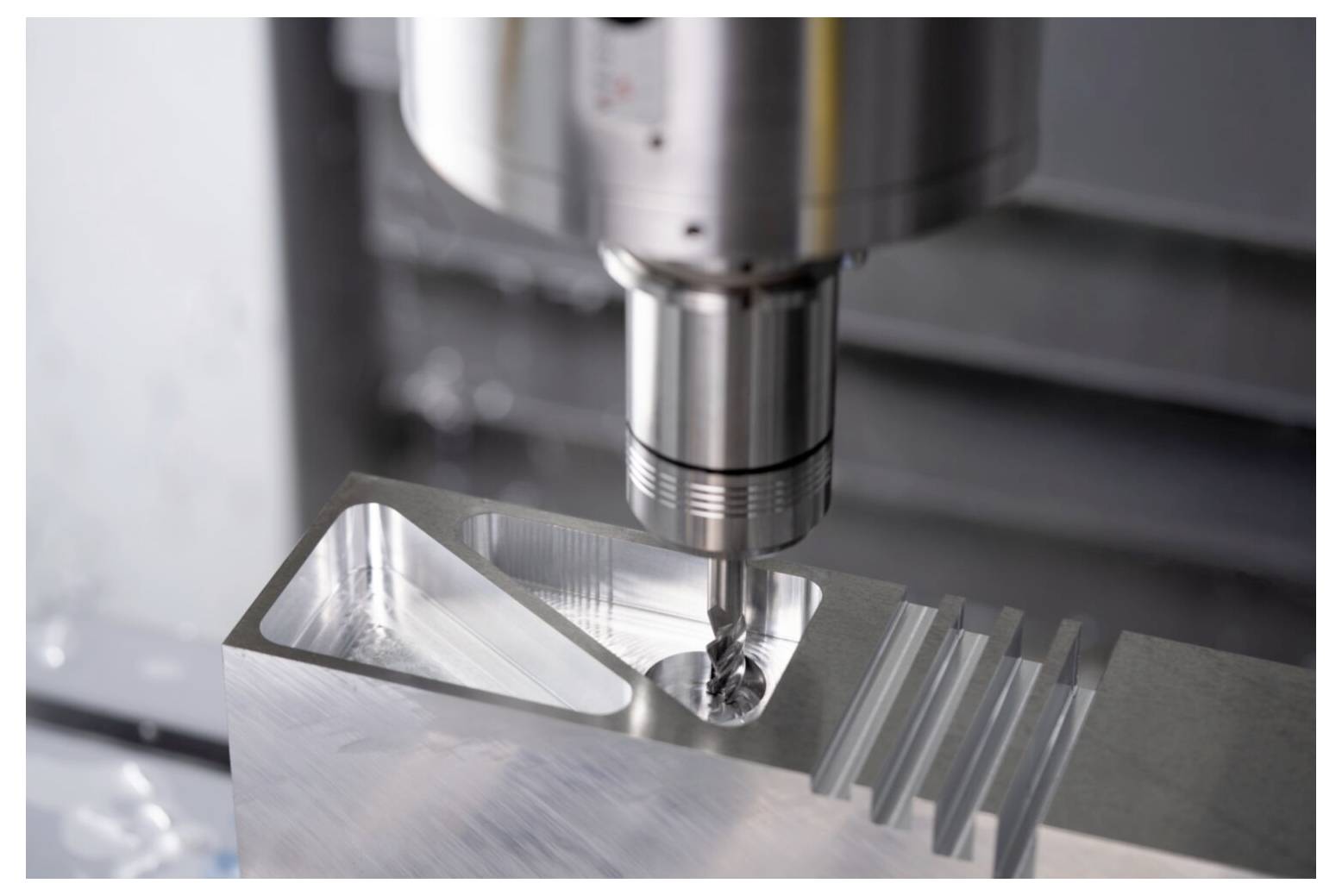 Eine CNC-Maschine, die präzise einen Metallblock bohrt und dabei den Fertigungsprozess in einer industriellen Umgebung demonstriert.