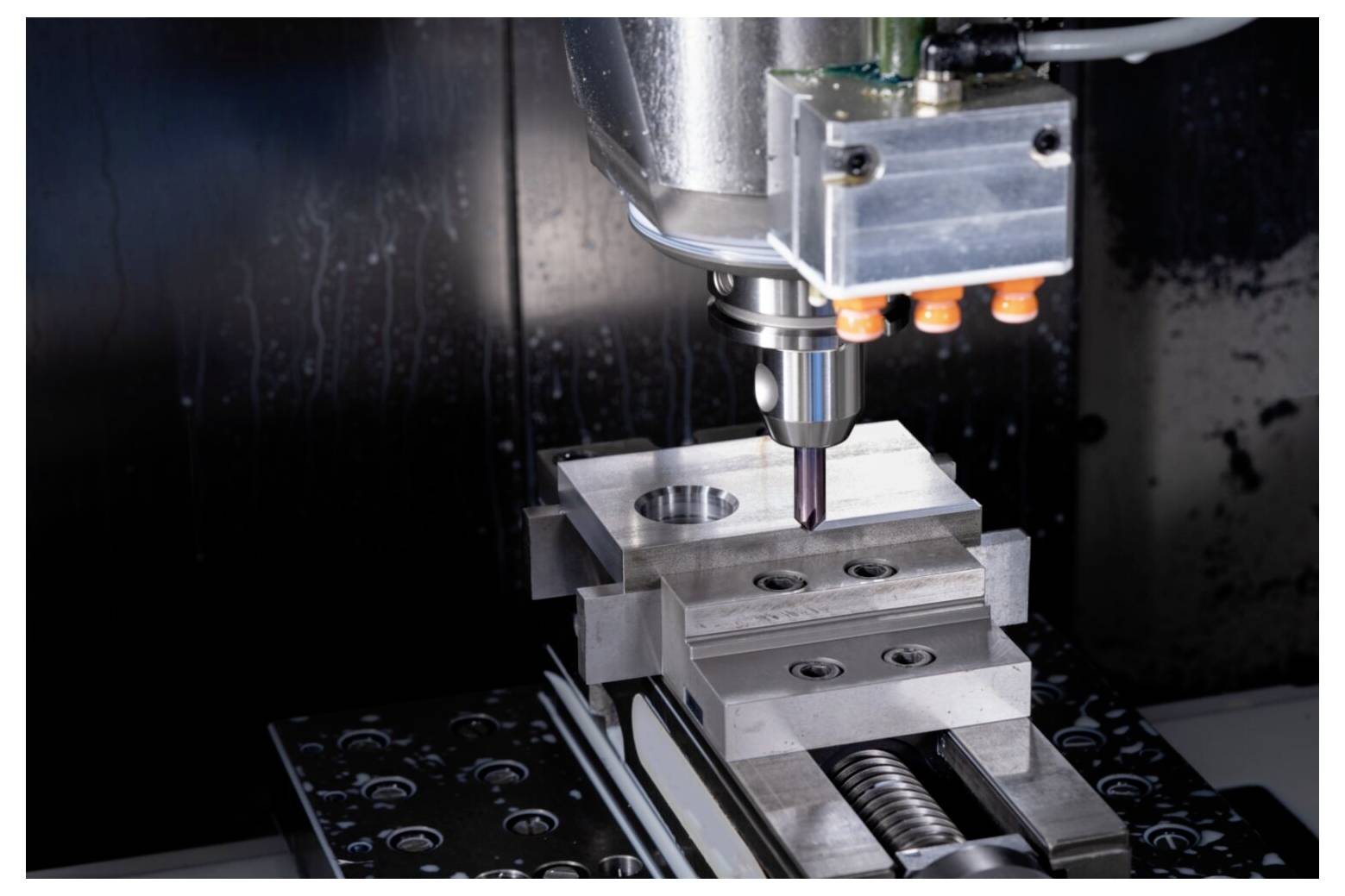 Eine CNC-Fräsmaschine, die präzise ein metallisches Werkstück bearbeitet und dabei fortschrittliche Fertigungstechnologie mit Fokus auf Genauigkeit und Detail demonstriert.