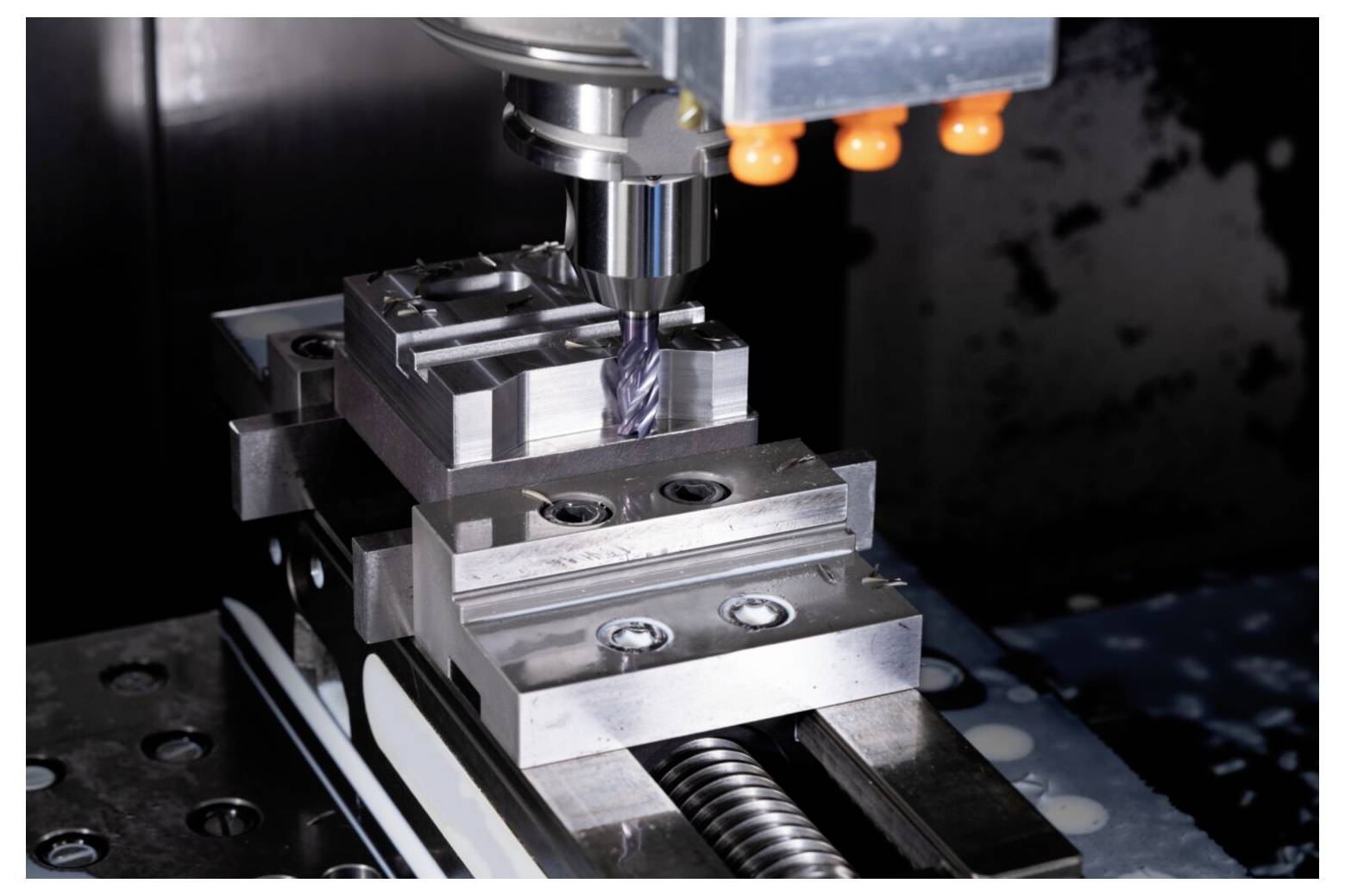Eine CNC-Maschine, die eine Metallkomponente fräst und präzise Werkzeugbewegungen sowie detaillierte handwerkliche Fertigkeiten in einem industriellen Umfeld zeigt.