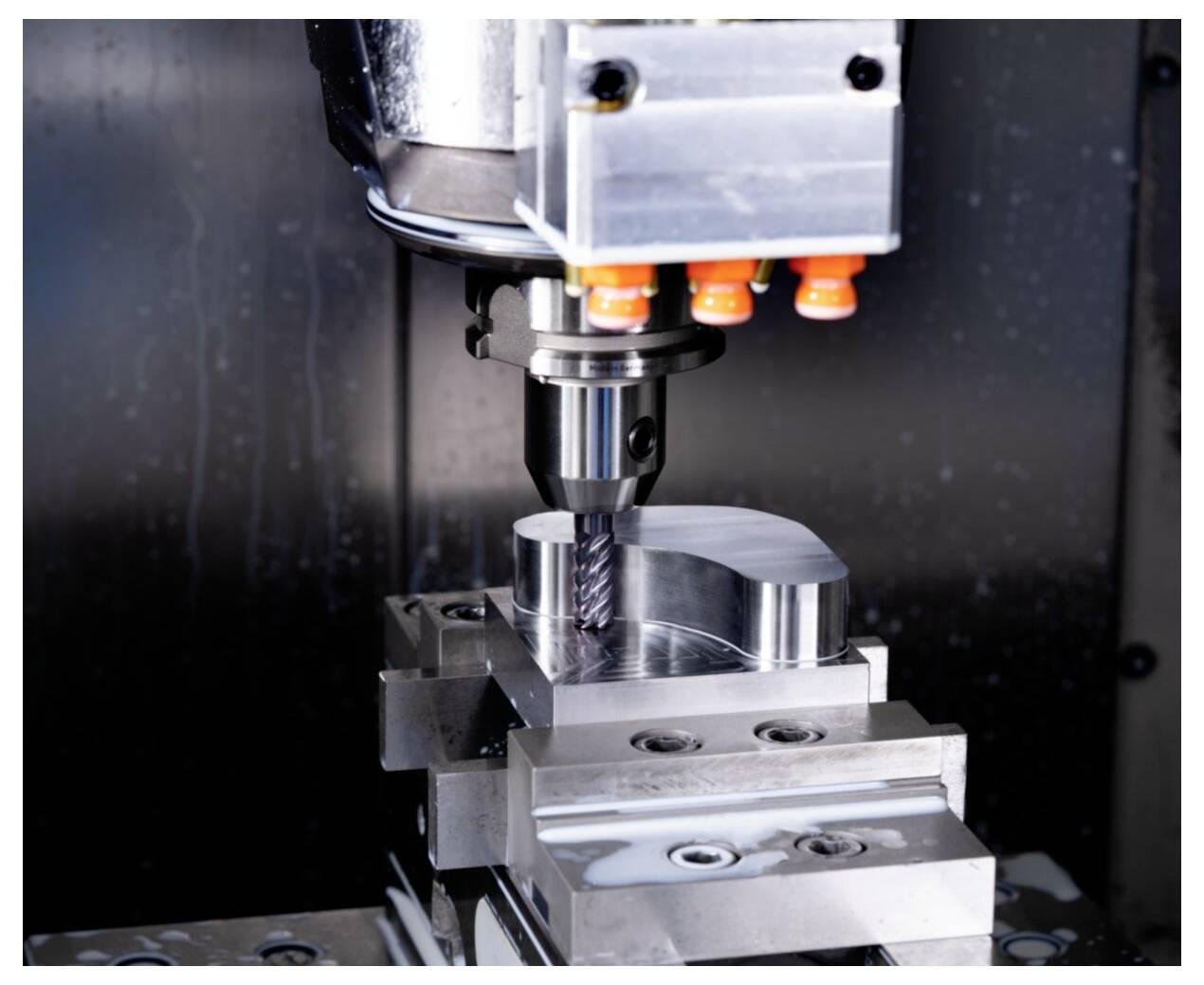 Eine CNC-Maschine fräst präzise eine metallische Komponente und demonstriert dabei Technologie und Automatisierung in der industriellen Fertigung.