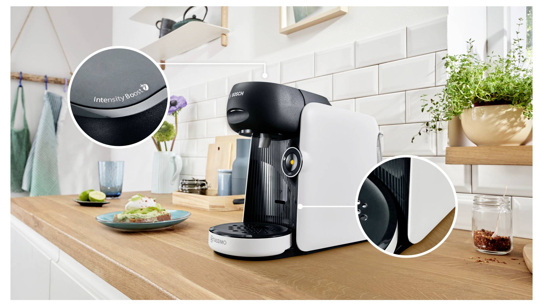 Eine moderne Kaffeemaschine auf einer Küchenarbeitsplatte mit einer ‚Intensitäts-Boost'-Funktion. In der Nähe befinden sich Toast und eine Topfpflanze.