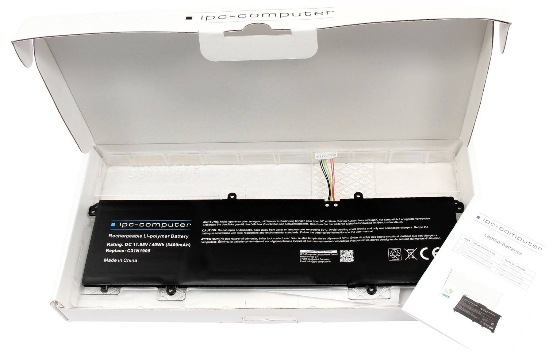 Laptop-Akku in Schachtel mit freiliegenden Kabeln, Etikett mit Modell und Spezifikationen, neben Bedienungsanleitung.