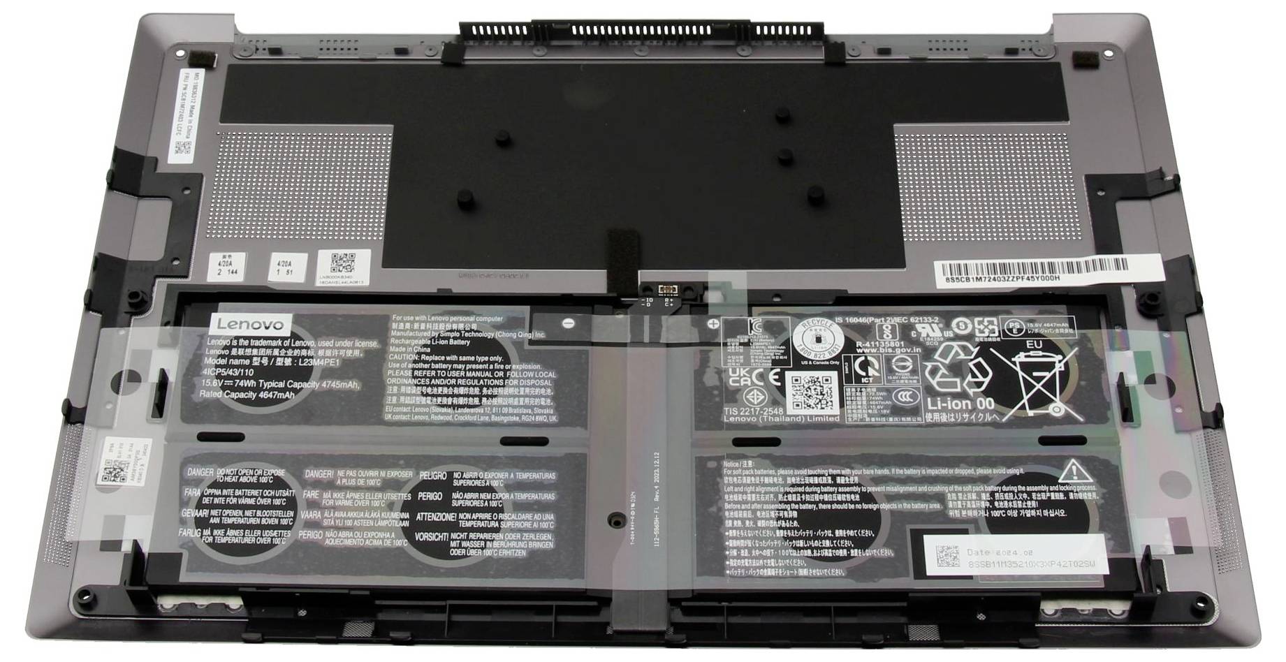 Öffnen der Rückseite eines Lenovo-Laptops mit Blick auf die Innenkomponenten, einschließlich Akku, Kühlventilatorbereich und verschiedenen Etiketten und Anschlüssen.