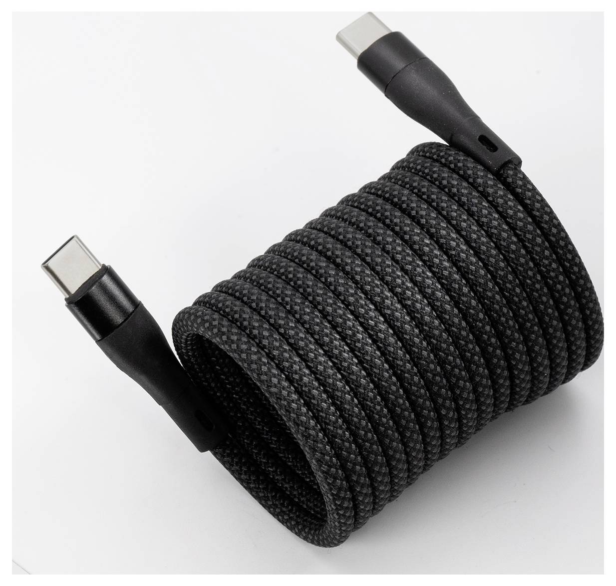 Ein gewickeltes schwarzes geflochtenes USB-C-Kabel mit sichtbaren Anschlüssen an beiden Enden.