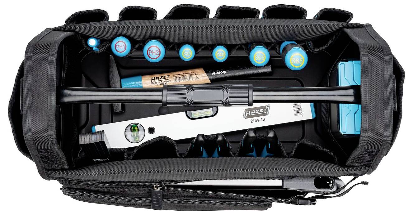 Eine Draufsicht auf eine Werkzeugtasche, gefüllt mit verschiedenen Werkzeugen, darunter Schraubendreher, eine Wasserwaage und Ratschenschlüsselgriffe, alle sorgfältig und ordentlich angeordnet.