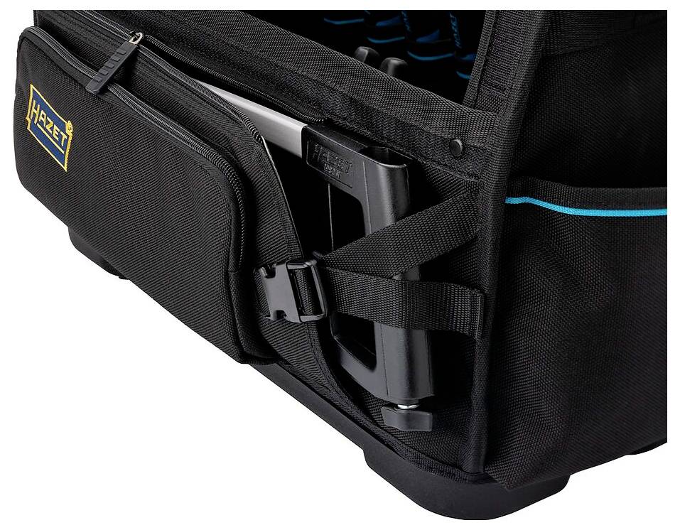 Schwarze Werkzeugtasche mit Seitentaschen, in der ein Elektrowerkzeug und ein Handbuch transportiert werden, mit der Marke 'Hazet' versehen.