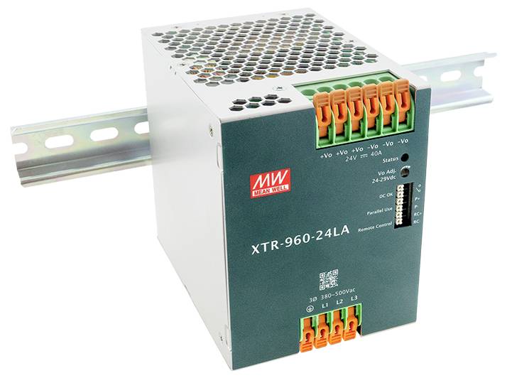 Ein Mean Well XTR-960-24LA Netzteil, montiert auf einer Schiene mit mehreren farbigen Anschlussklemmen für elektrische Verbindungen.