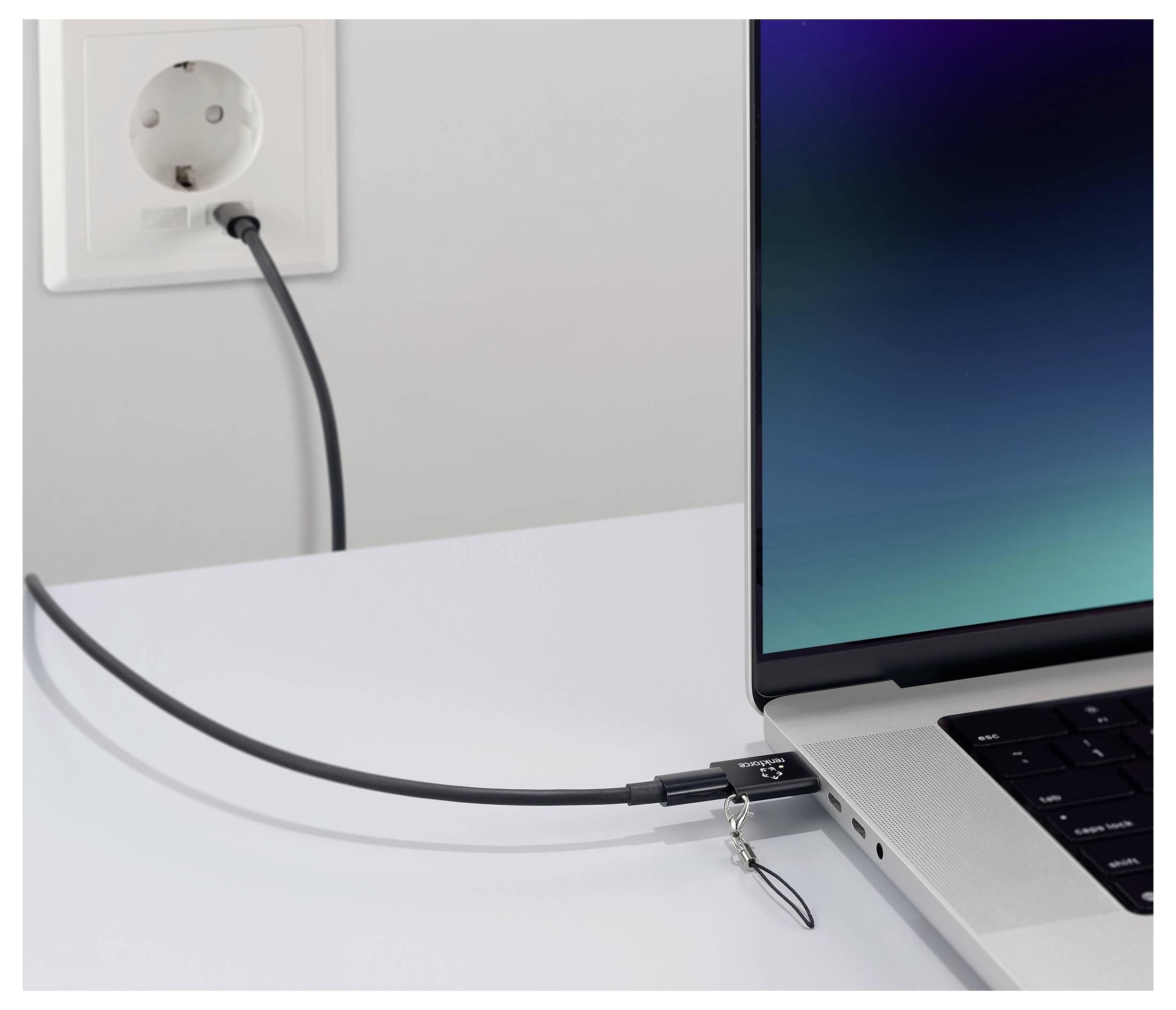 Ein Laptop ist über ein Sicherheitskabelschloss an eine Steckdose angeschlossen, was Diebstahl während der Nutzung verhindert.