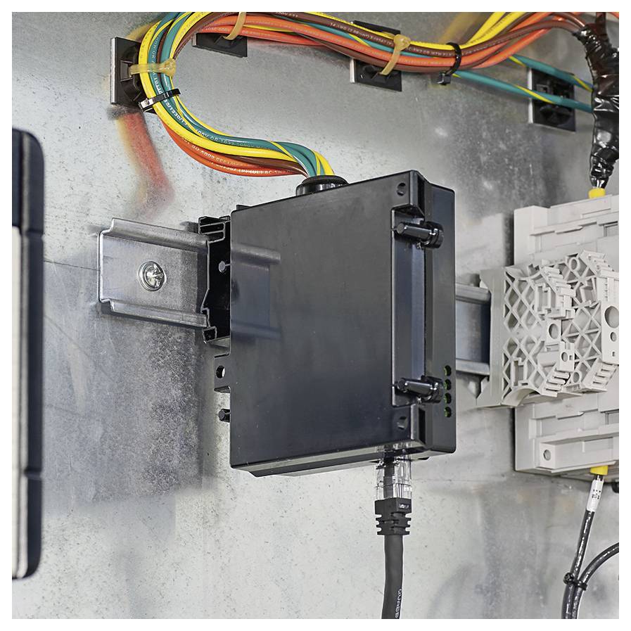 Ein schwarzes elektronisches Gerät, das auf einer Metalloberfläche montiert ist, mit farbigen Kabeln darüber, verbunden mit einer Stromversorgung und einem Netzwerkkabel.