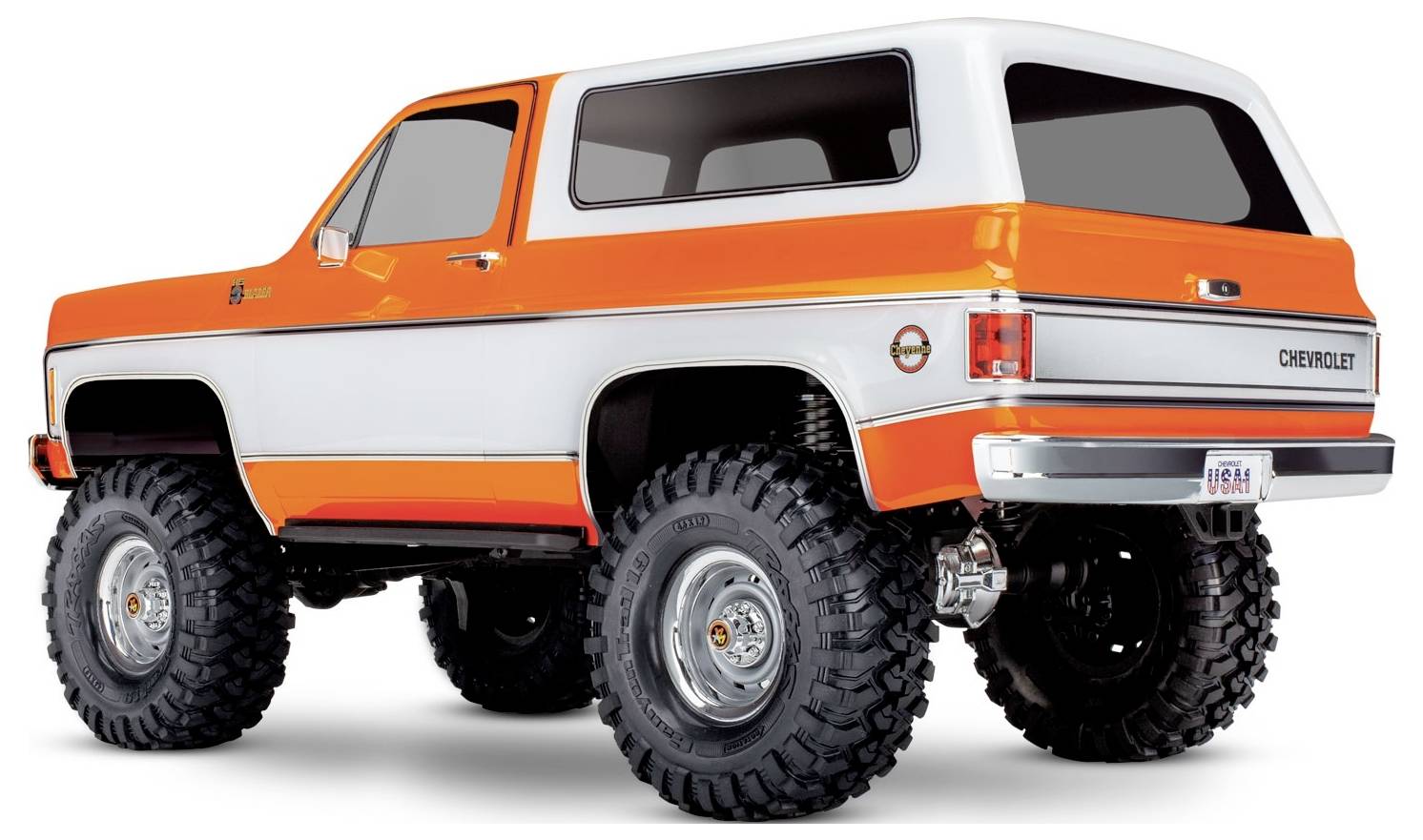 Ein Vintage-SUV mit orange-weißer Lackierung, Fahrwerkserhöhung und großen Geländereifen, von der Rückseite seitlich betrachtet.