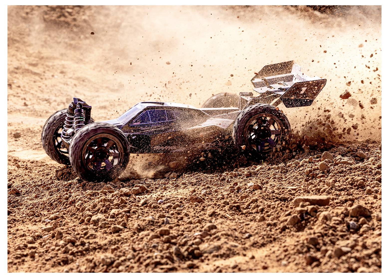 Ein RC-Auto rast über steiniges Gelände und wirbelt dabei Staub auf. Die Szene fängt die dynamische Bewegung und die raue Landschaft ein.