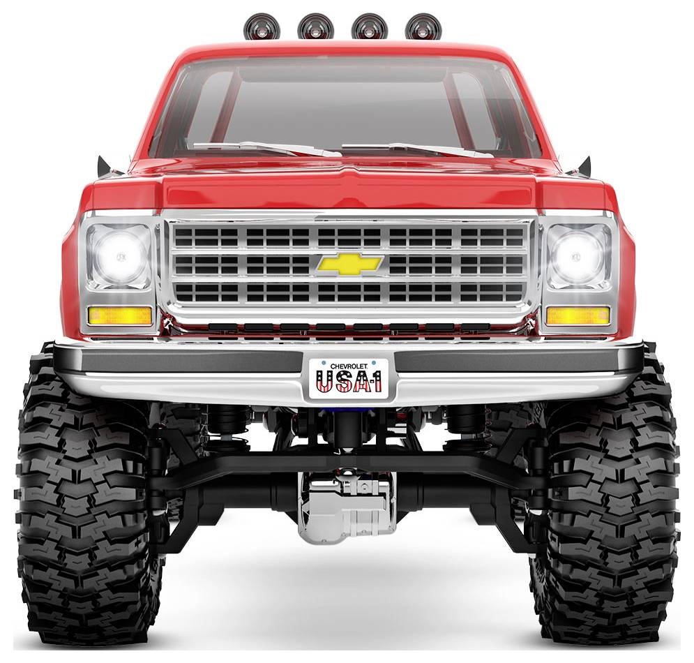 Ein hellrotes Geländefahrzeug mit großen Reifen, ausgerüstet für raues Gelände, von vorne betrachtet, das seinen robusten Aufbau und seine markante Gestaltung zur Geltung bringt.