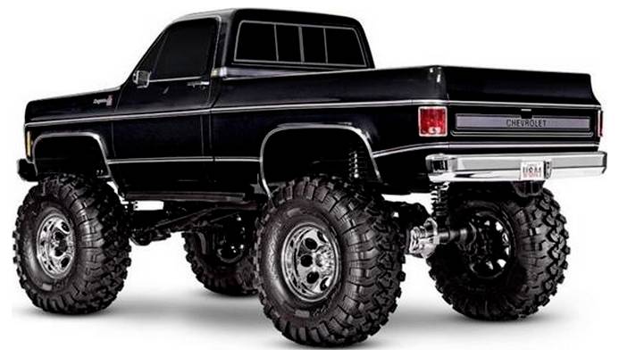 Ein angehobener schwarzer Pickup-Truck mit großen Geländereifen und 'Chevrolet'-Branding auf der Heckklappe, von einer Rückseite-Seitenansicht gezeigt.