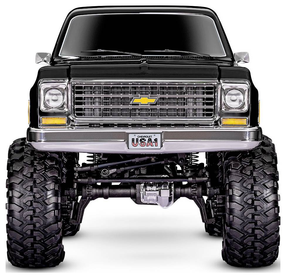 Ein angehobener schwarzer Chevrolet-Truck mit großen Geländereifen, ausgestattet mit einem Chromgrill, Chevy-Logo und dem Nummernschild 'USA-1'.