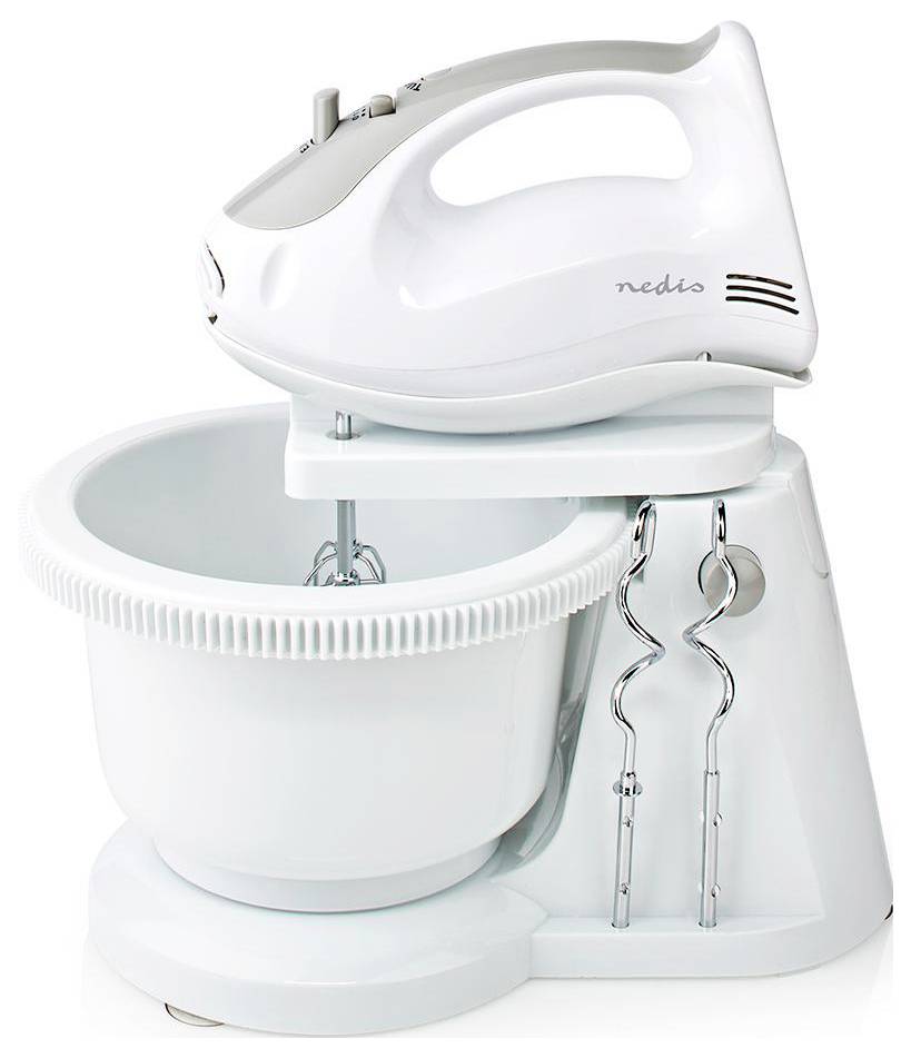 Ein weißer Standmixer mit abnehmbarer Rührschüssel, Rührbesenaufsätzen und Zubehörhaken daneben, der für Backaufgaben und Kocharbeiten in der Heimküche konzipiert ist.