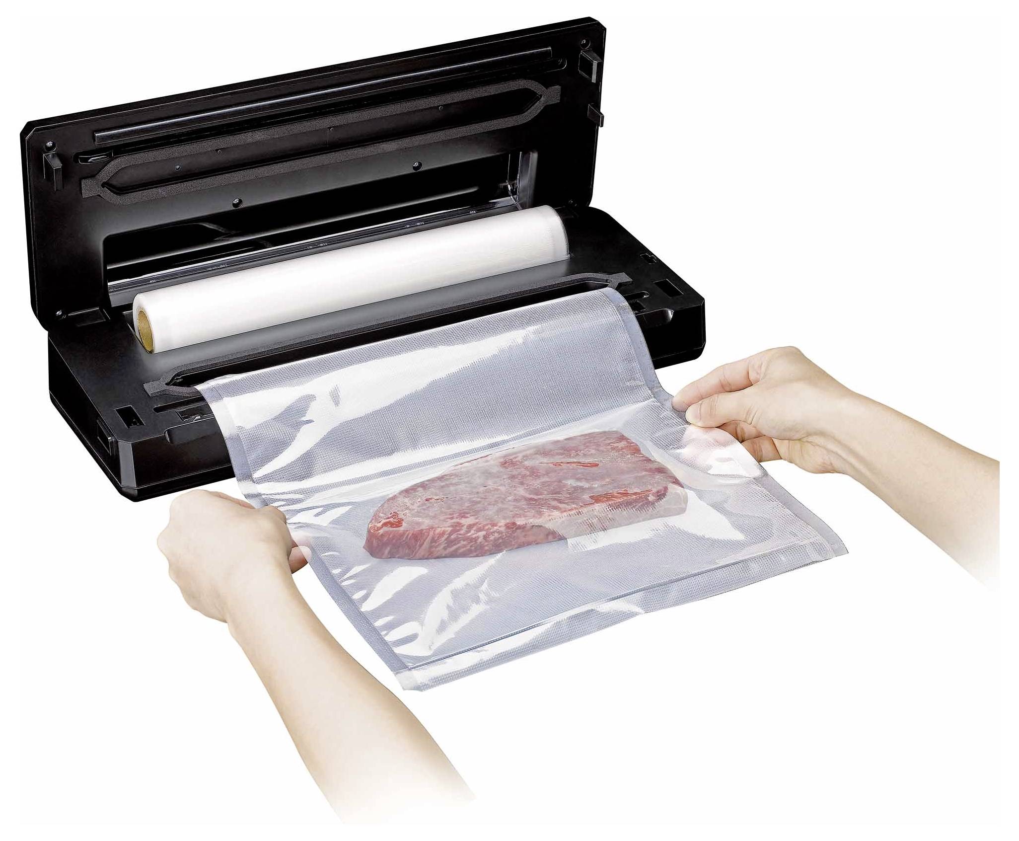 Ein Vakuumiergerät im Einsatz, das ein rohes Steak in einer Plastiktüte versiegelt. Hände halten das offene Ende der Tüte und bereiten sie zum Versiegeln vor.