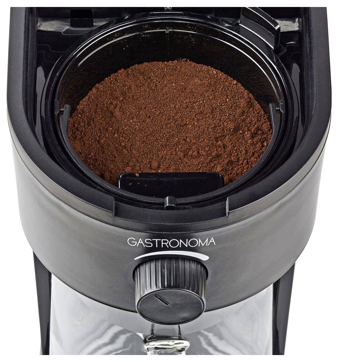 Eine von 'Gastronoma' markierte Kaffeemühle, von oben betrachtet, die frisch gemahlenen Kaffee in ihrer Mahlkammer zeigt.