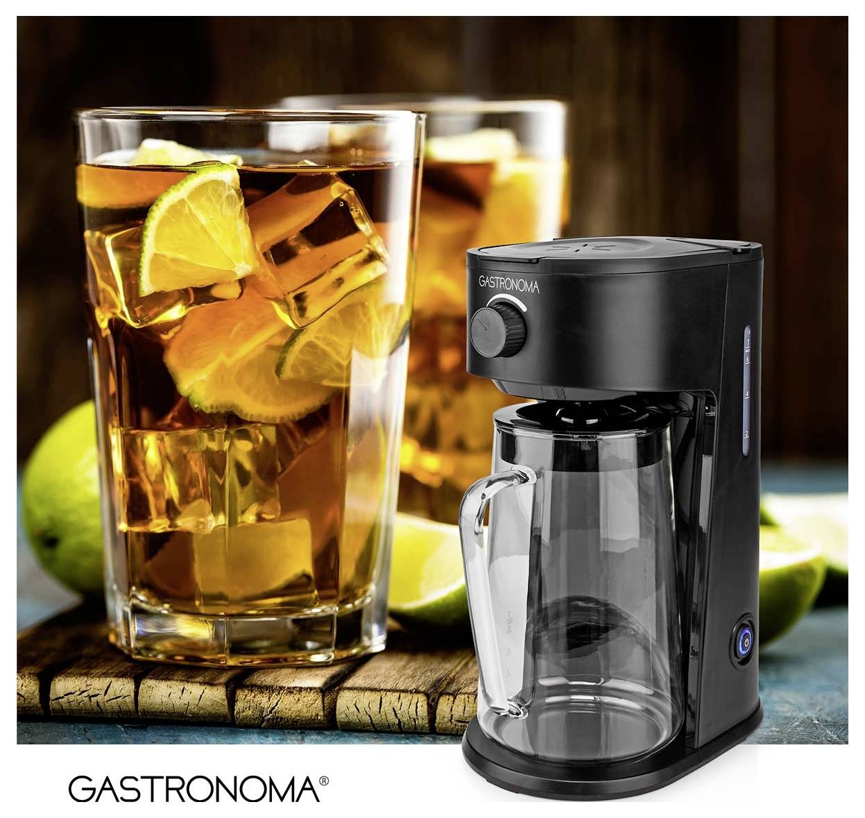 Eine schwarze Kaffeemaschine mit einer Glaskaraffe steht neben einem großen Glas Eistee mit Zitronen- und Limettenscheiben.