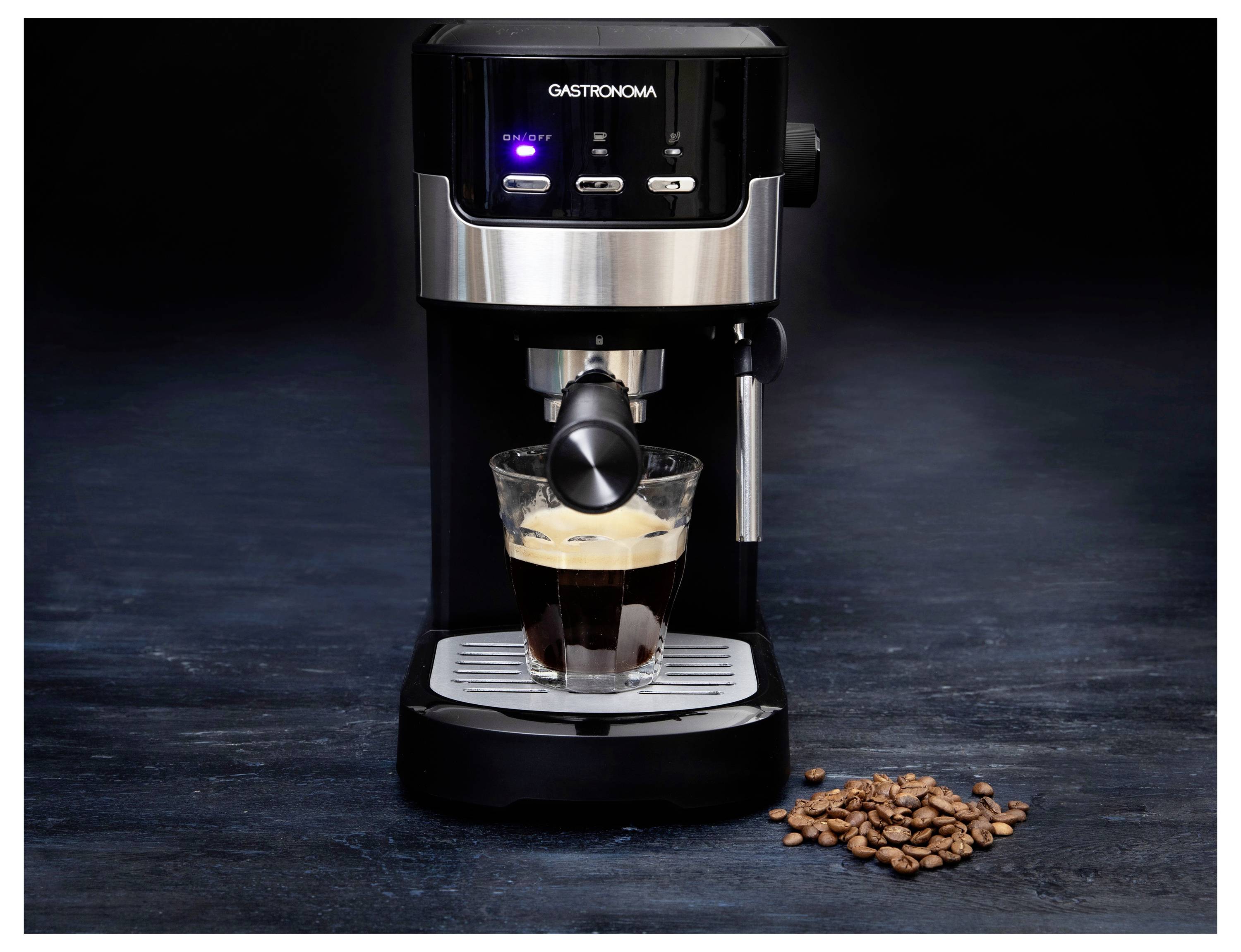 Espressomaschine brüht Kaffee in eine durchsichtige Glasstasse mit Kaffeebohnen, die auf einer dunklen Oberfläche verstreut sind.