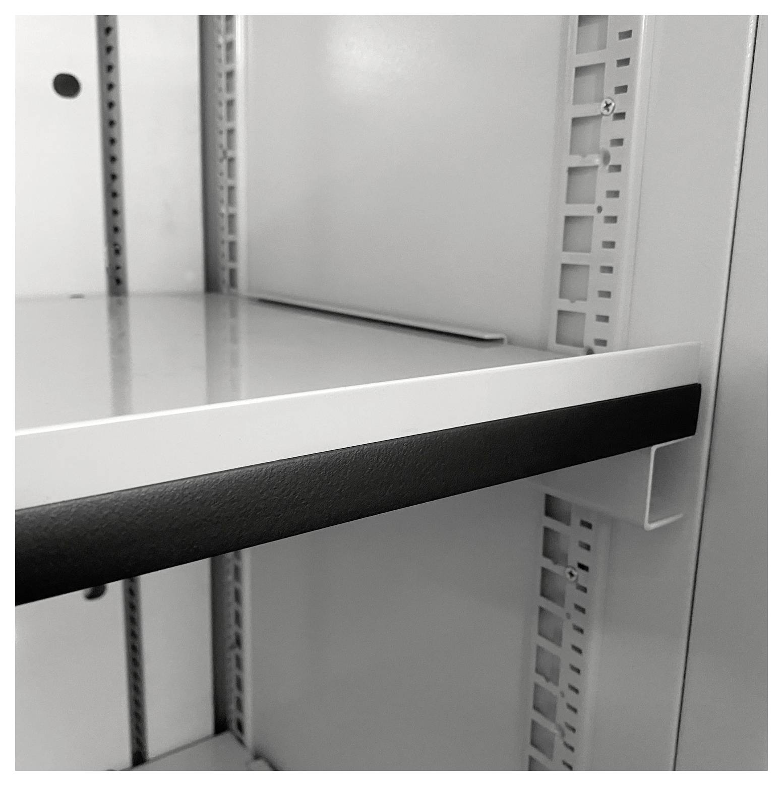 Eine Nahaufnahme eines leeren Regals in einem Lagerraum, die einen Metallrahmen und verstellbare Halterungen an den Seiten zeigt.