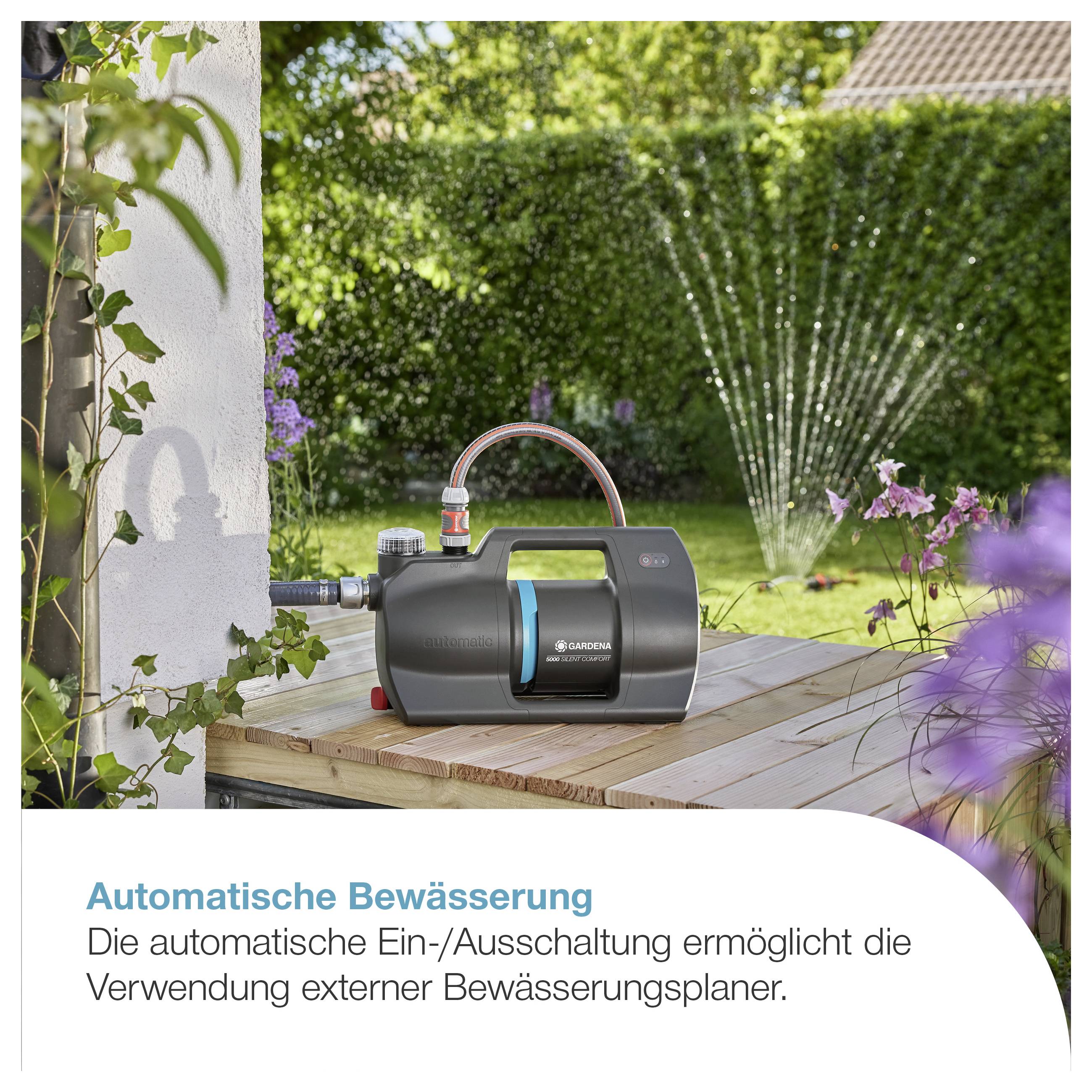 Automatische Bewässerung mit Gartenschlauch- und Pumpengerät im Garten; Sprinkler bewässert den Rasen im Hintergrund.