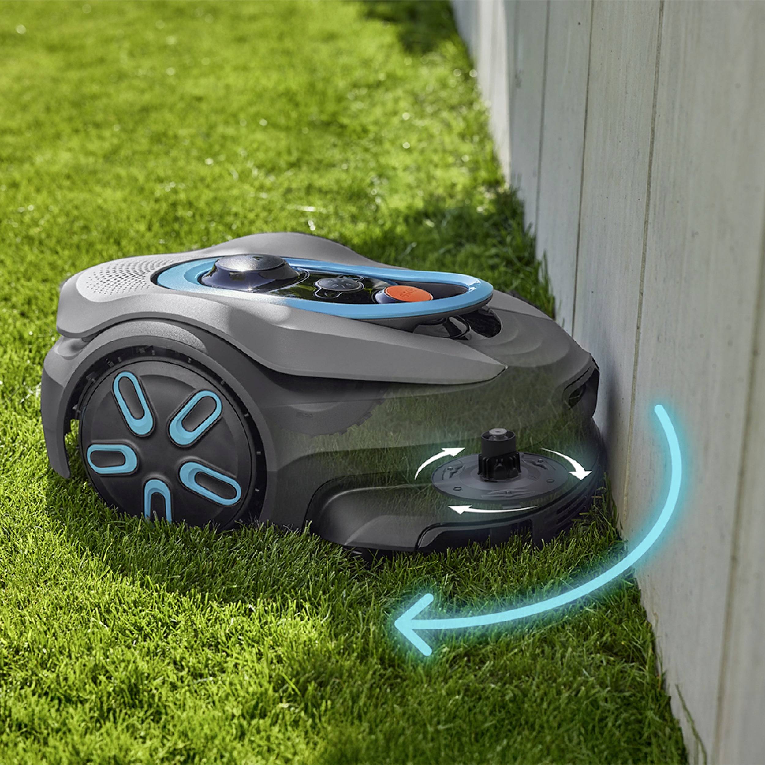 Ein Rasenmähroboter mit blauen Akzenten trimmt Gras entlang eines weißen Zauns und demonstriert automatisierte Rasenplege.