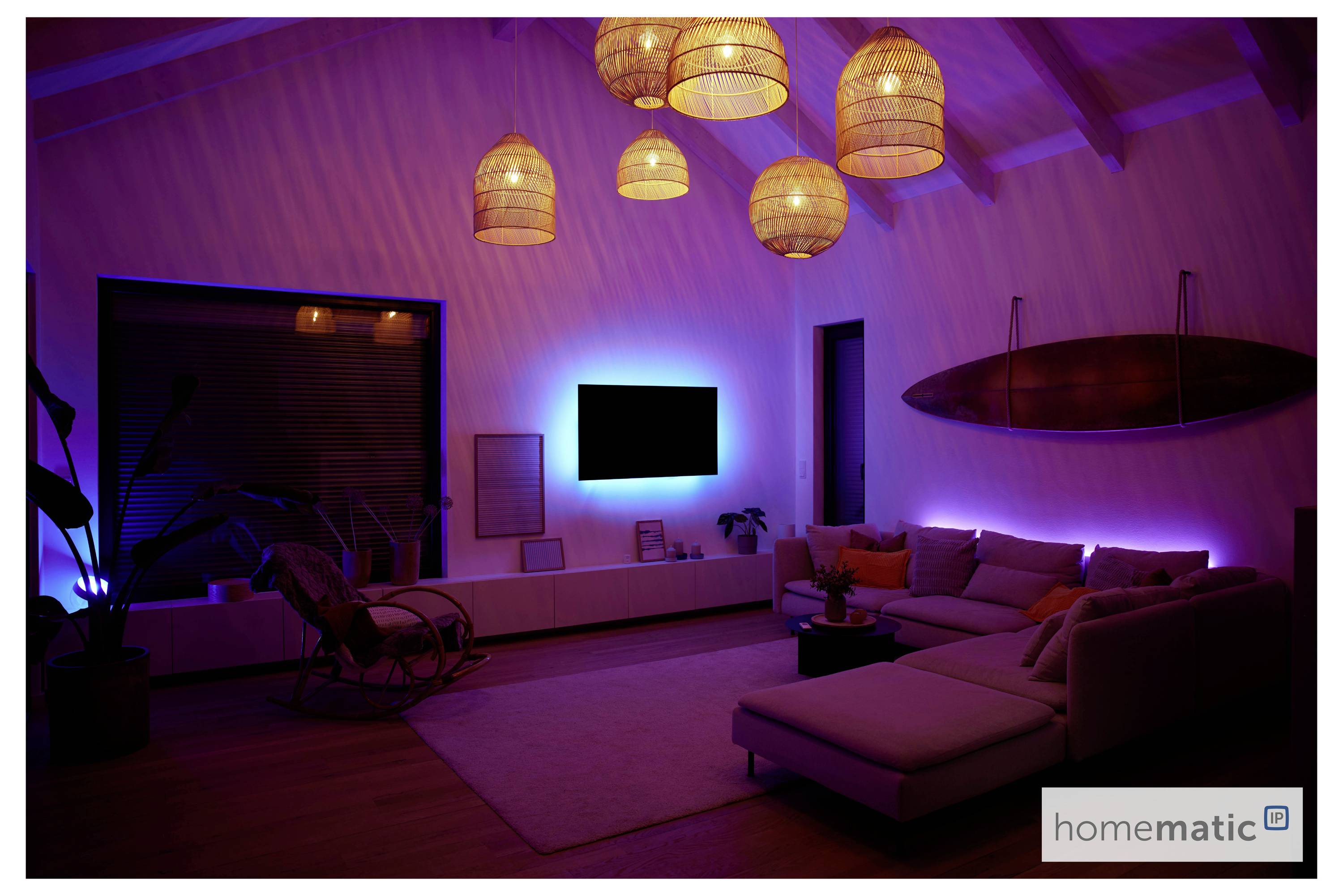 Ein modernes Wohnzimmer mit ambientem violettem Licht, geflochtenen Pendelleuchten, einem montierten Surfbrett und einem Ecksofa, das zu einem wandmontierten Fernseher ausgerichtet ist.