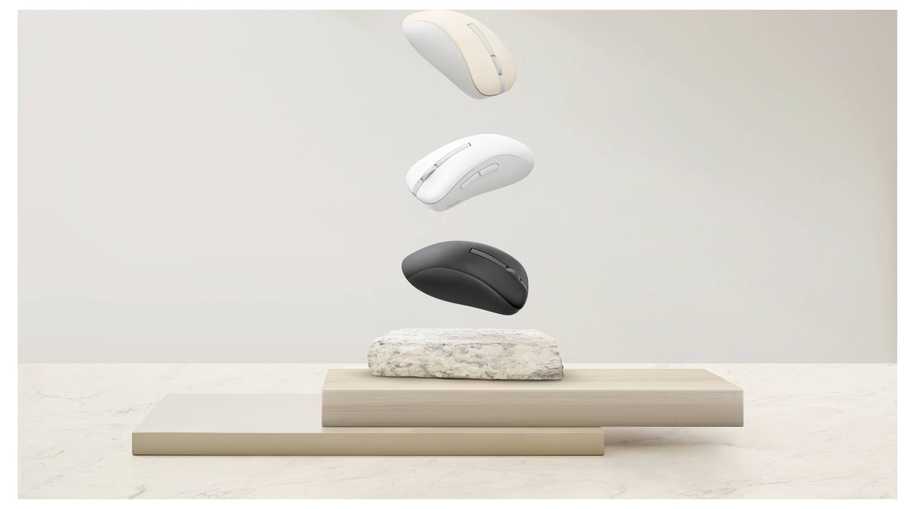 Drahtlose Computer-Mäuse in Beige, Weiß und Schwarz, die über gestapelten beigen und steinernen Oberflächen schweben und die Farbvielfalt veranschaulichen.