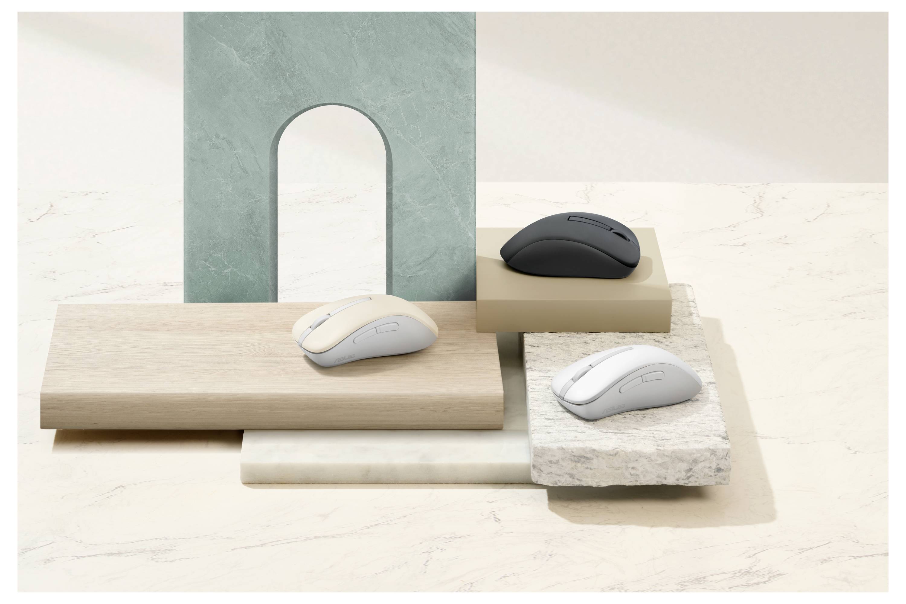 Drei drahtlose Computermäuse werden auf gestapelten Podesten aus Marmor, Holz und Stein vor einem minimalistischen Hintergrund präsentiert.