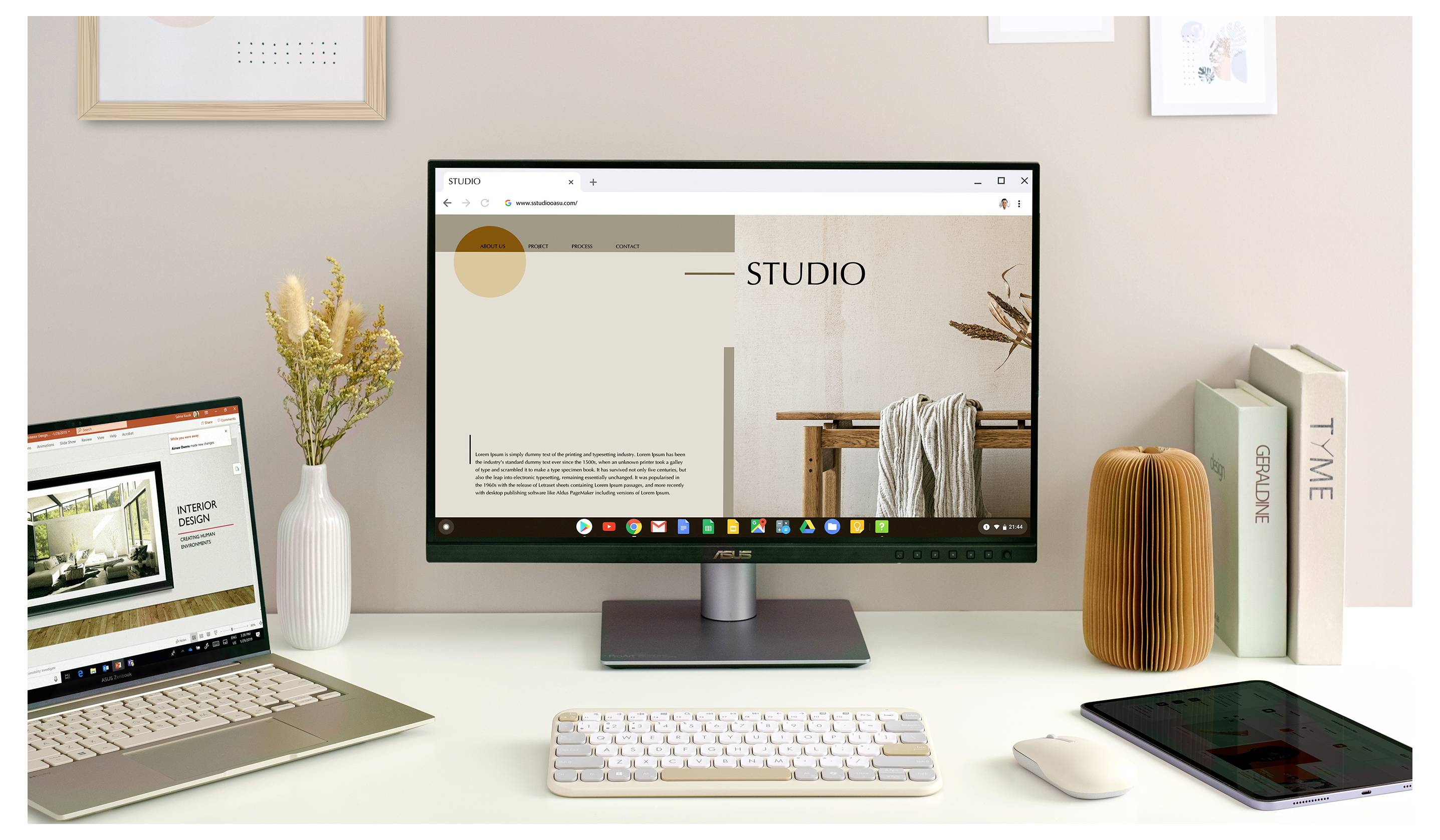 Ein moderner Arbeitsplatz mit einem Desktop-Monitor, der eine 'STUDIO' Webseite anzeigt, einem Laptop, einer Tastatur, Dekorationselementen und Büchern.
