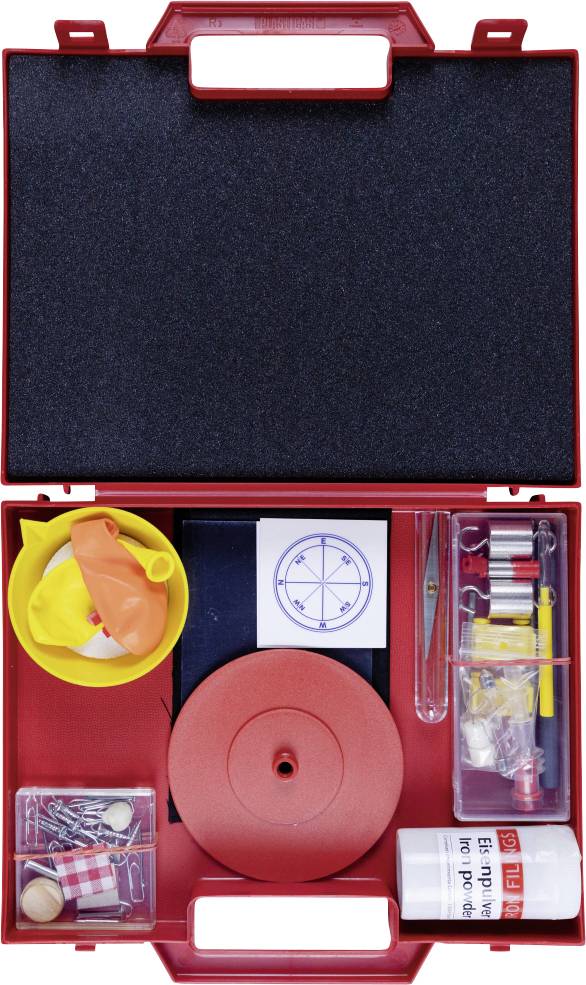 Rote Schachtel mit verschiedenen Gegenständen, einschließlich eines Kompasses, kleiner Röhrchen, eines gelben Trichters, Luftballons und einem Behälter mit Pulver mit Text.