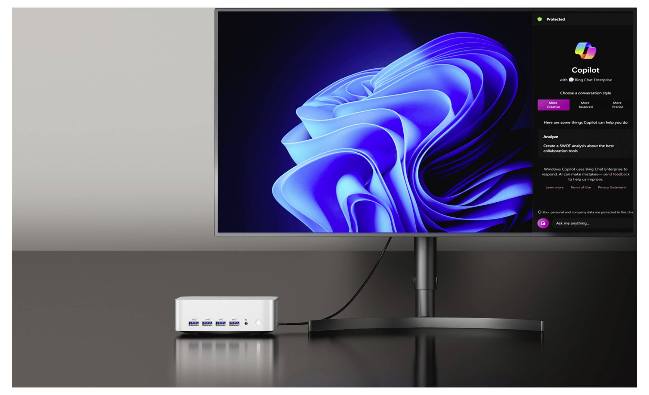 Ein Computermonitor zeigt ein leuchtendes blaues abstraktes Design, das einer Windows-Benutzeroberfläche ähnelt, neben einem Computerhub mit mehreren USB-Anschlüssen.