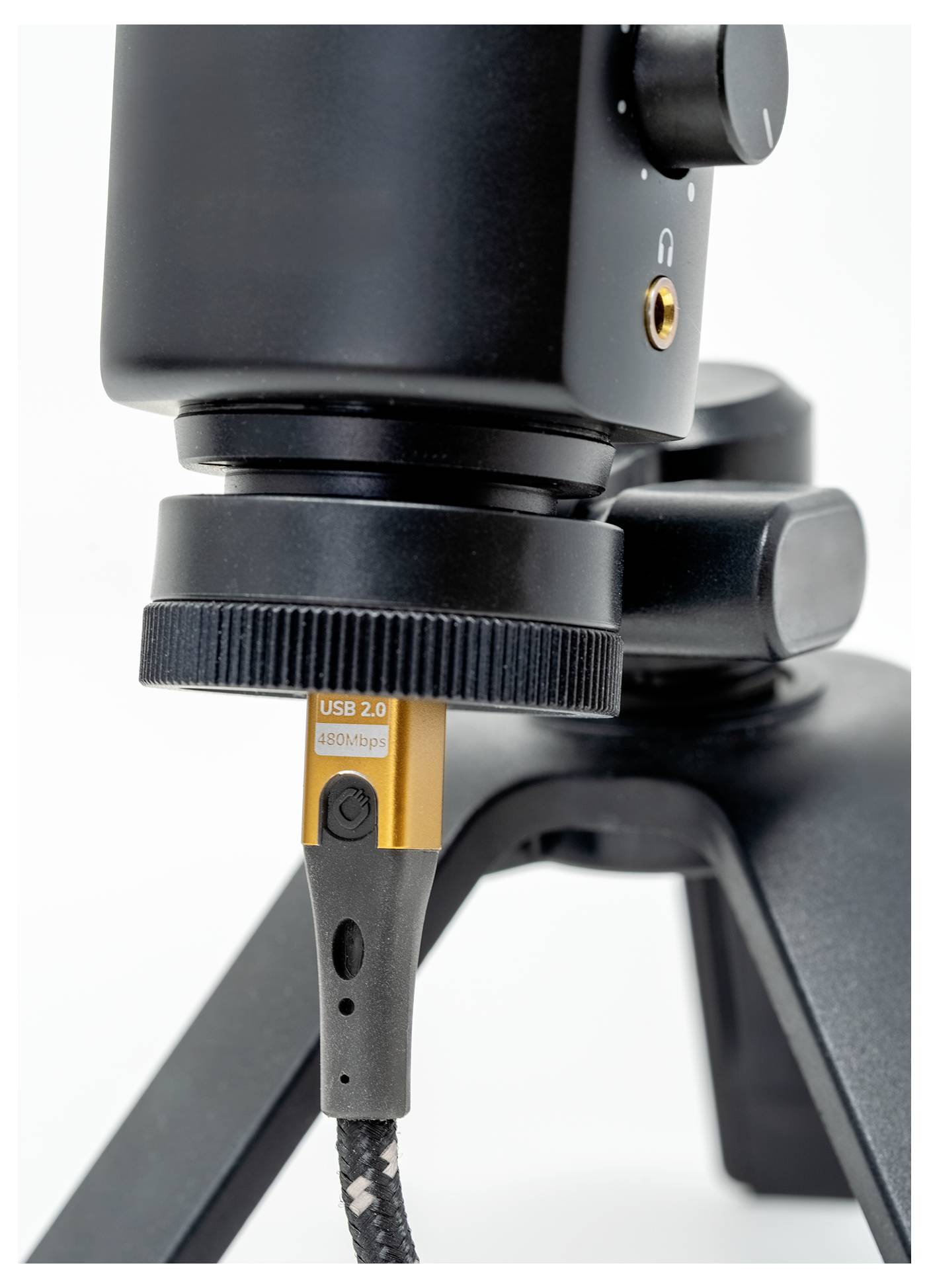 Ein Nahaufnahmebild eines USB-2.0-Kabels, das in ein schwarzes Audiogerät auf einem Stativ eingesteckt ist, wobei Details der Konnektivität hervorgehoben werden.