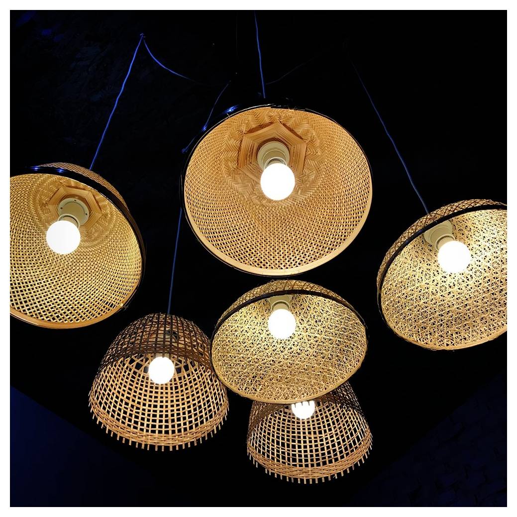 Sechs gewebte Rattan-Pendelleuchten mit leuchtenden Glühbirnen hängen von einer dunklen Decke und werfen warmes Licht, wodurch eine gemütliche Atmosphäre entsteht.