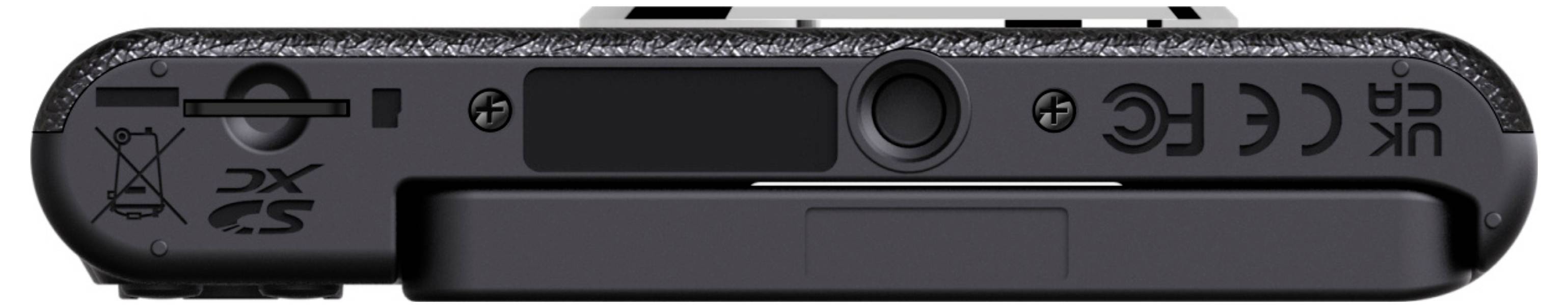 Das Bild zeigt die Unterseite eines schwarzen elektronischen Geräts mit verschiedenen Symbolen und Text, die wahrscheinlich Warenzeichen und behördliche Konformität anzeigen.