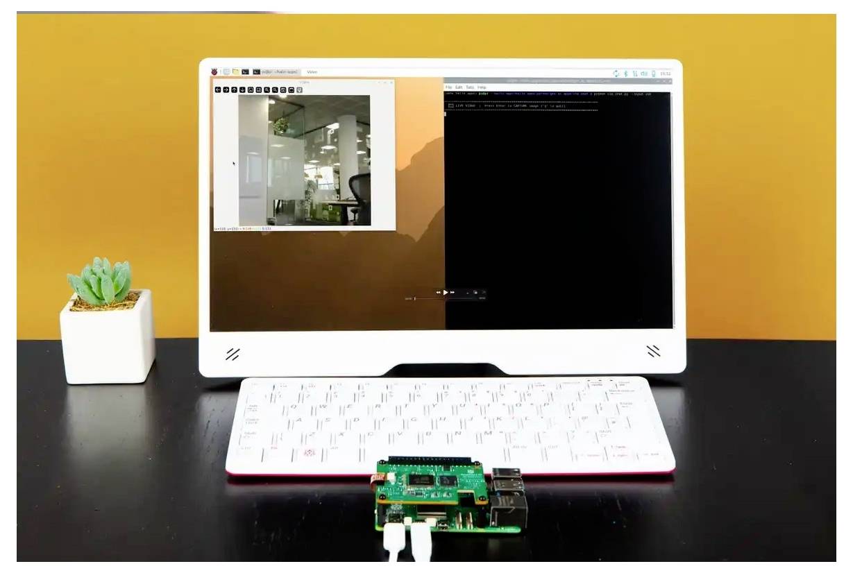 Ein kompakter Computer-Setup mit einer weißen Tastatur und einem Bildschirm, auf dem ein Code-Editor und ein Bild angezeigt werden. Eine kleine Pflanze sitzt auf der linken Seite.